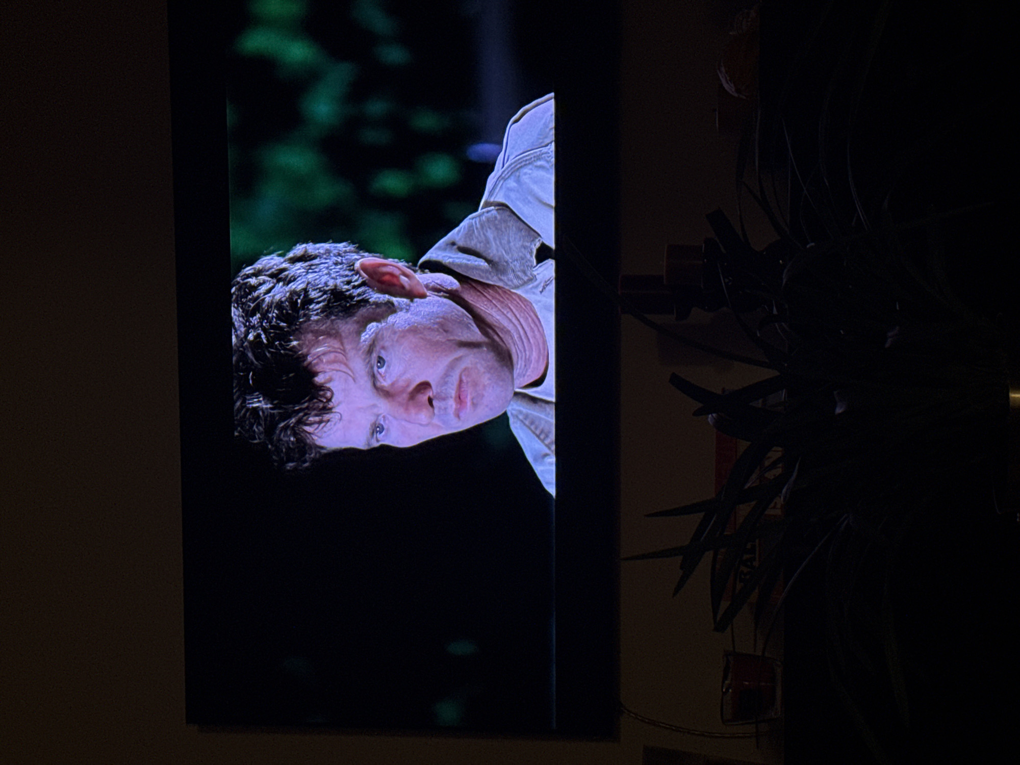 Man shown on TV screen, person resting in Neuilly-sur-Seine