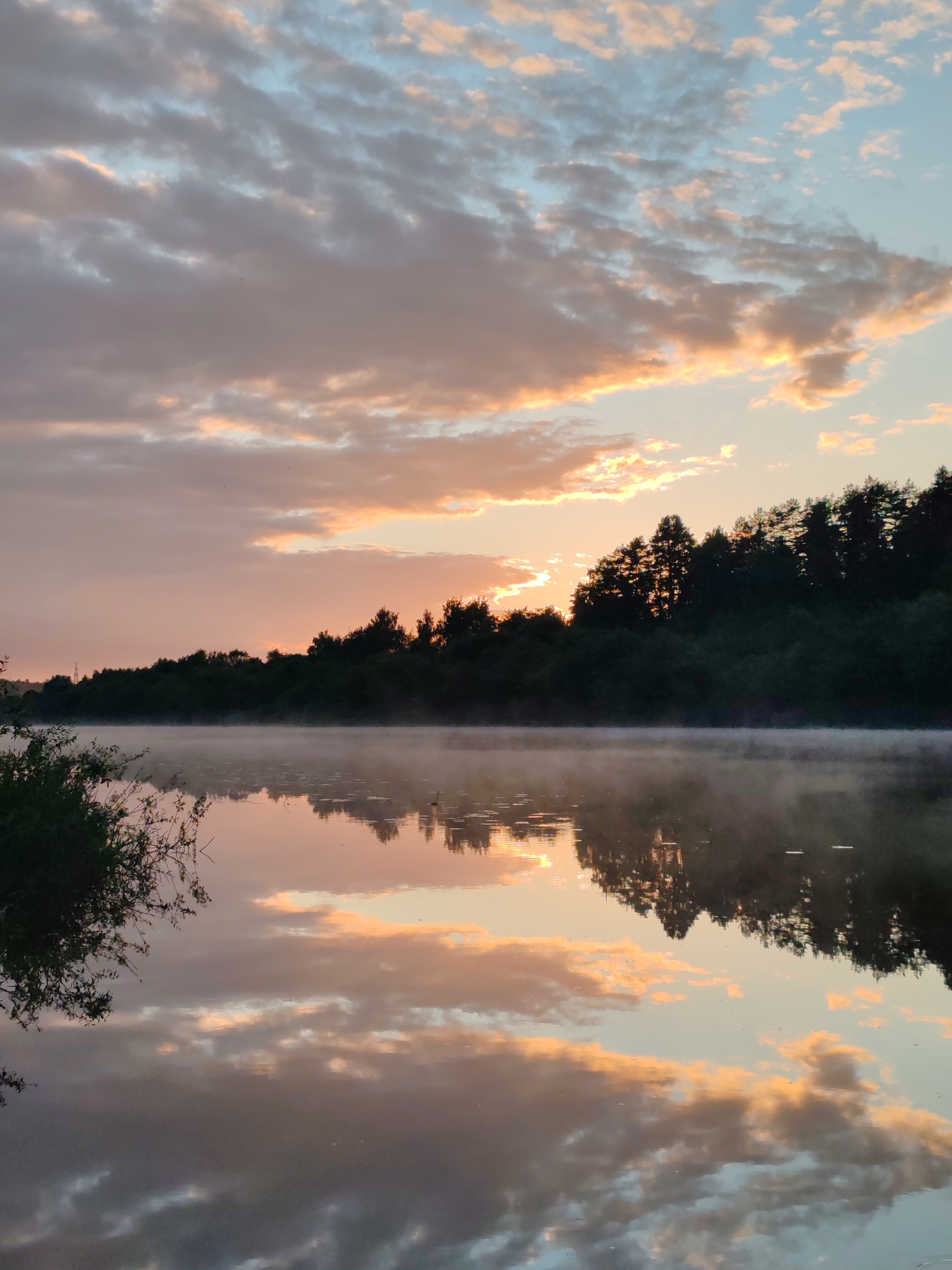 Dawn fishing session on misty Western Dvina River