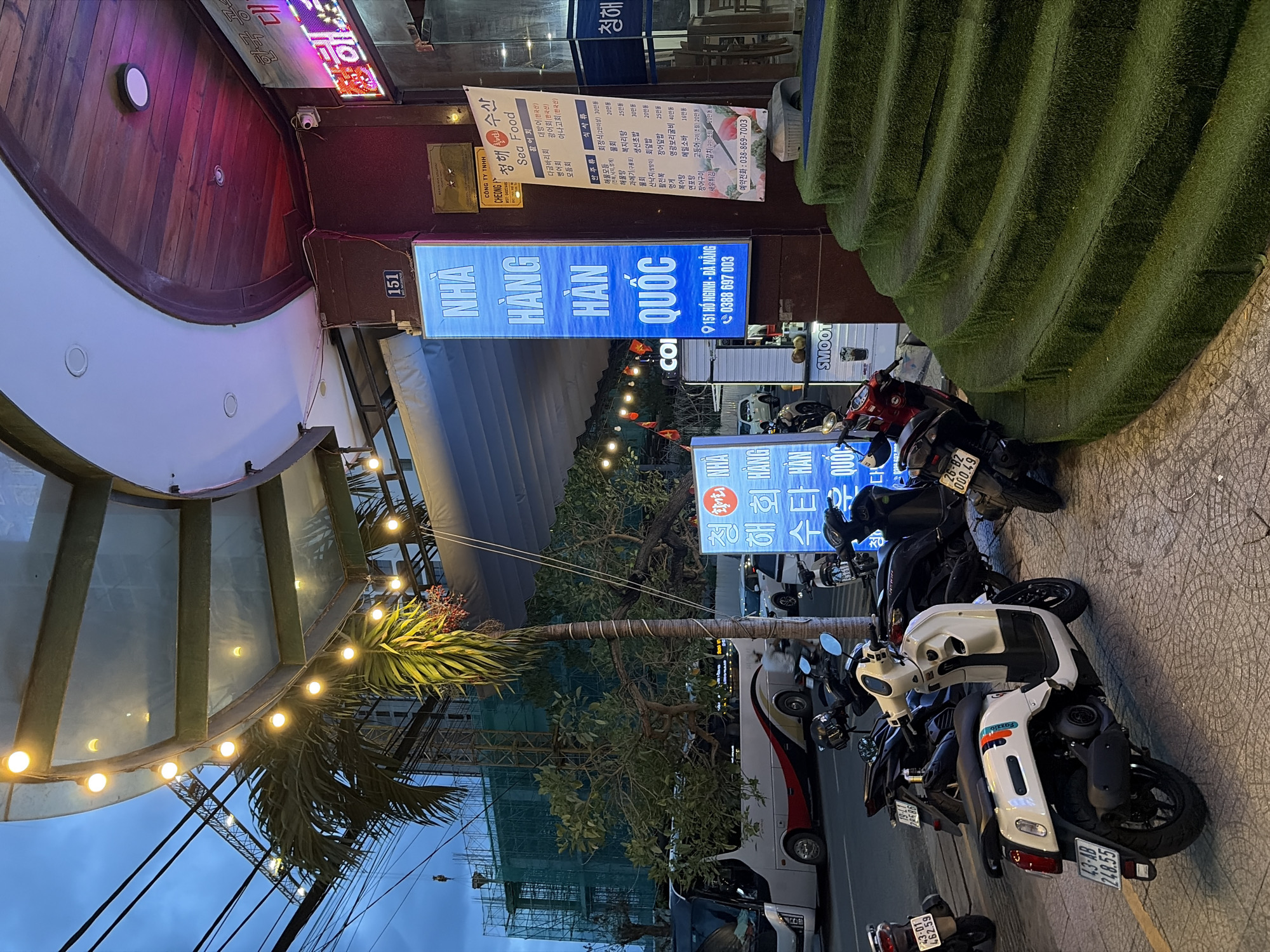 Đà Nẵng street life at dusk — food stalls, hotels, and rising skyline