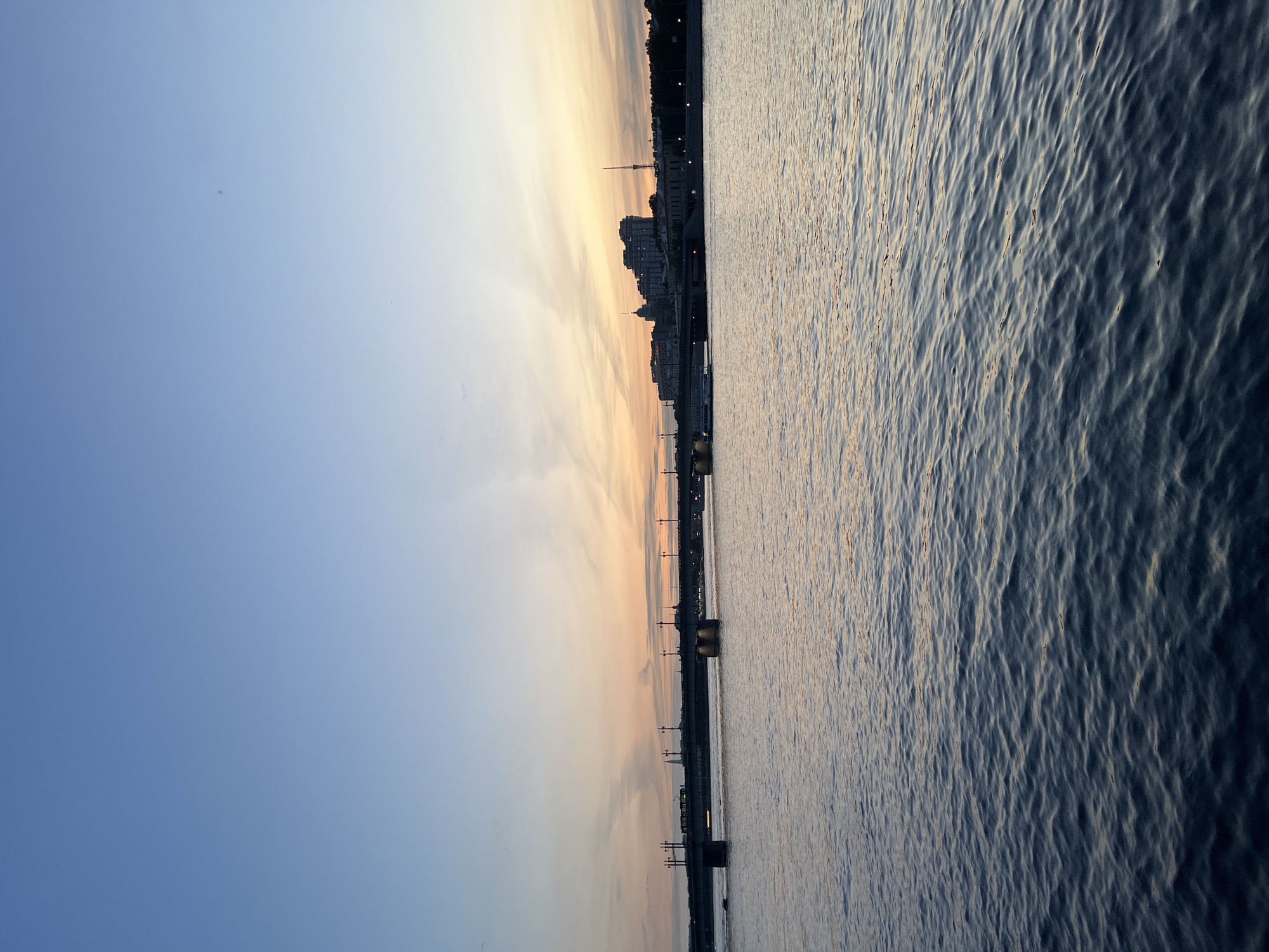 Twilight cityscape captured showing river, bridge, and gradient sky