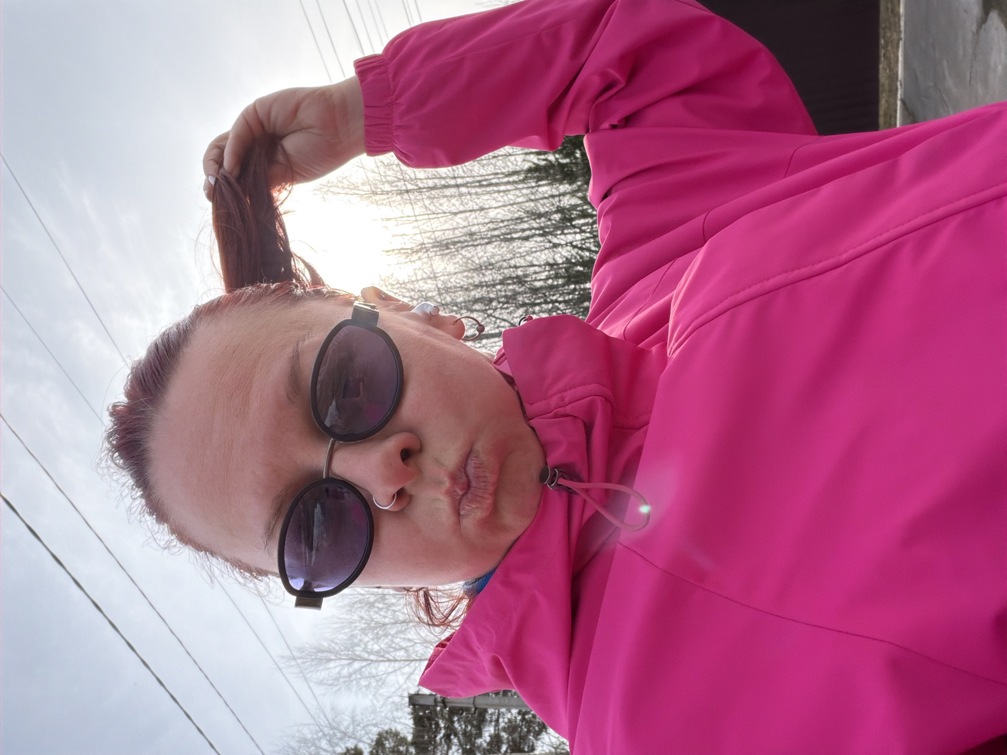 Woman takes selfies on overcast street in Chaikovsky, Russia
