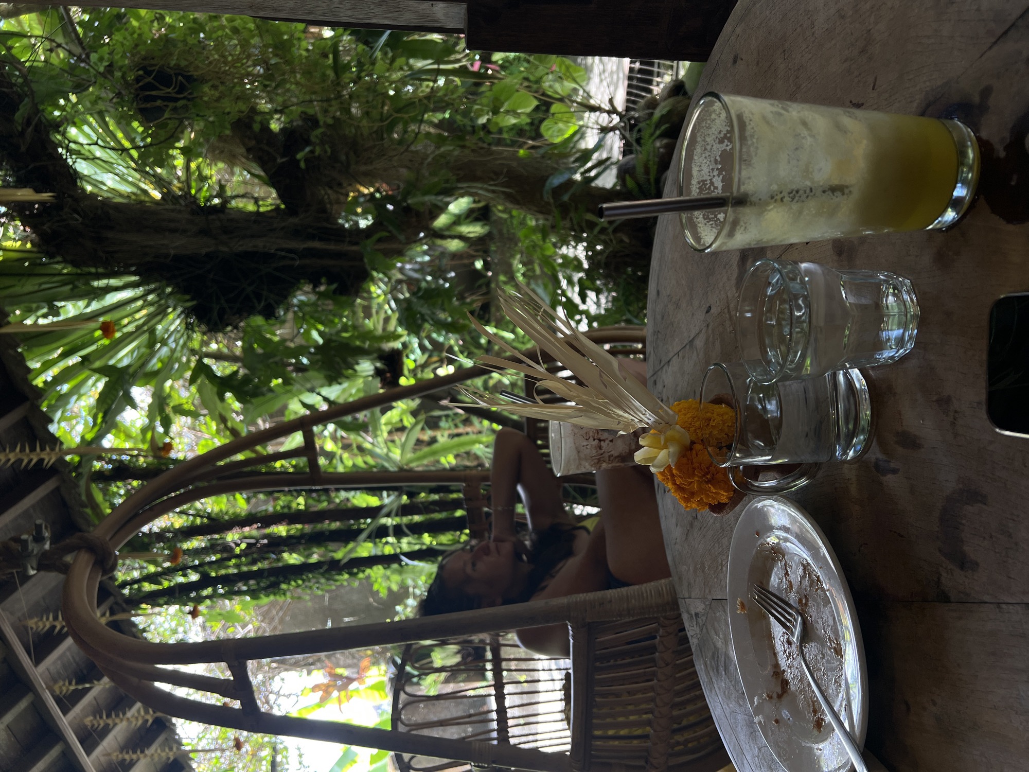 Woman sits at outdoor table in Ubud early morning