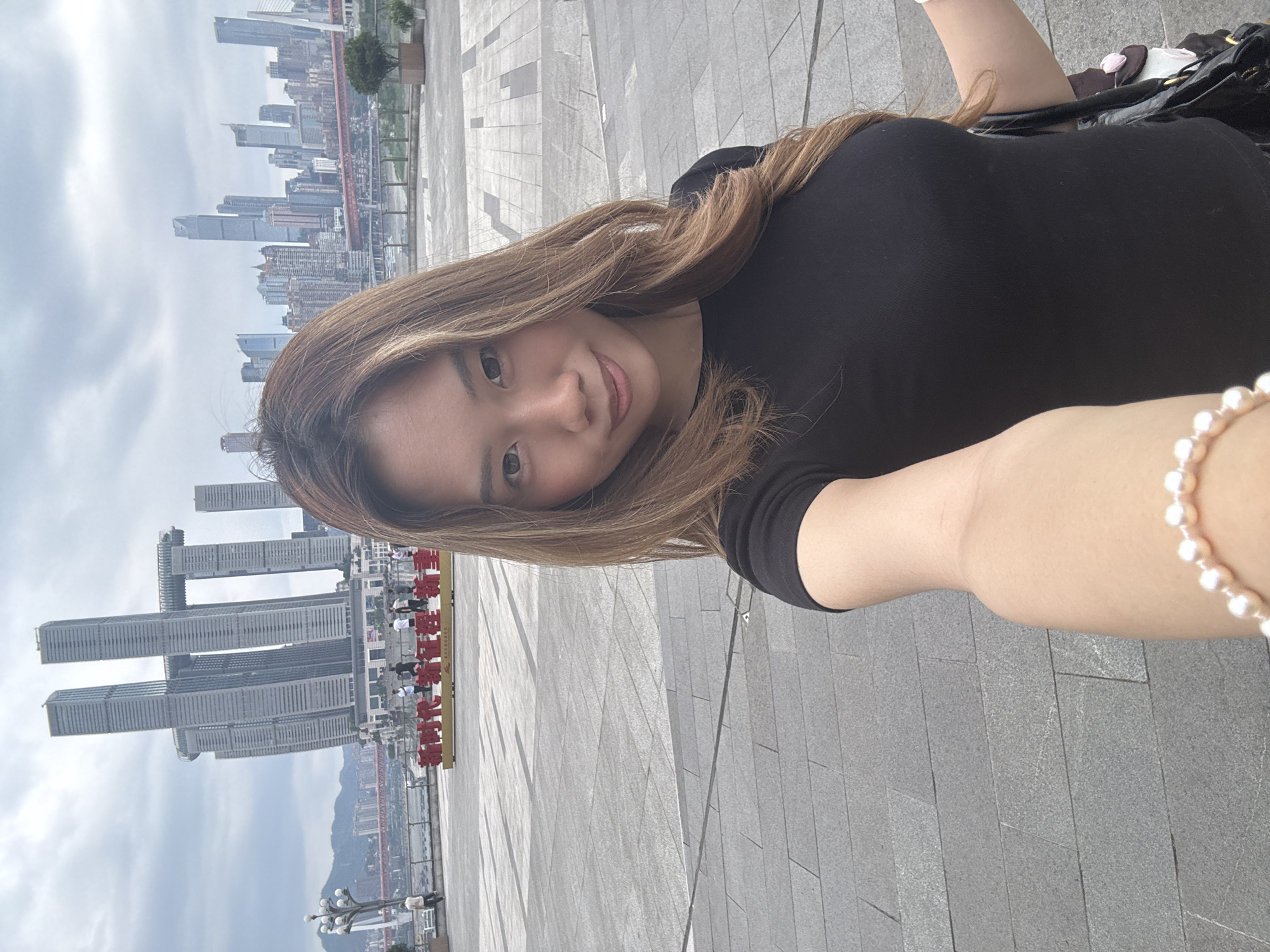 Woman takes selfies at Chongqing observation deck with city backdrop