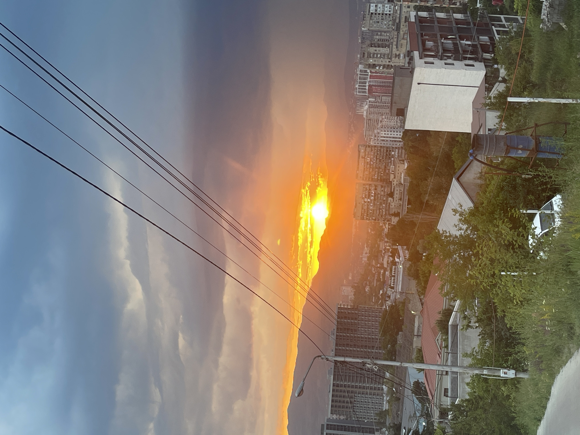 Sunset illuminates Tbilisi cityscape amid clouded evening skies