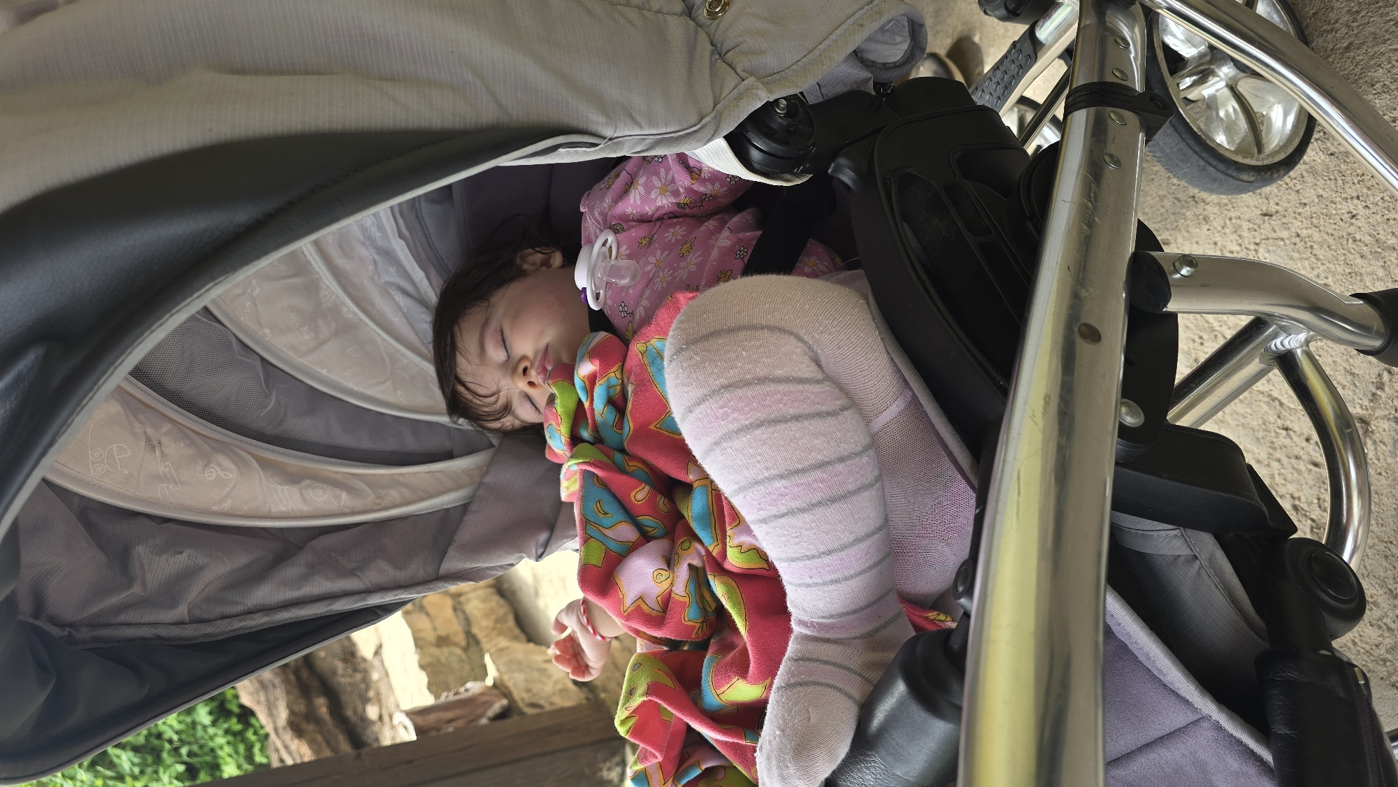 Child sleeps peacefully in stroller in Bulgarian village
