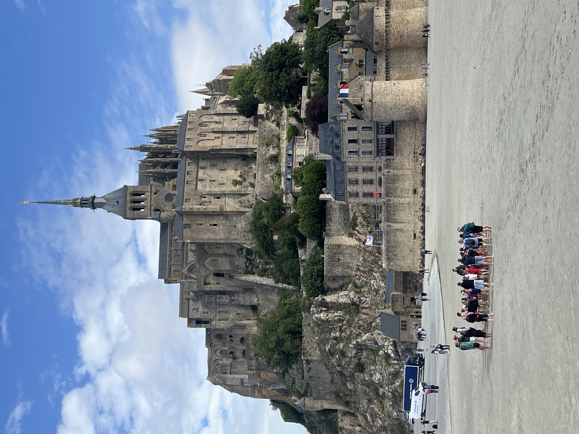 Morning tourists explore Mont Saint-Michel's medieval streets and tidal plains