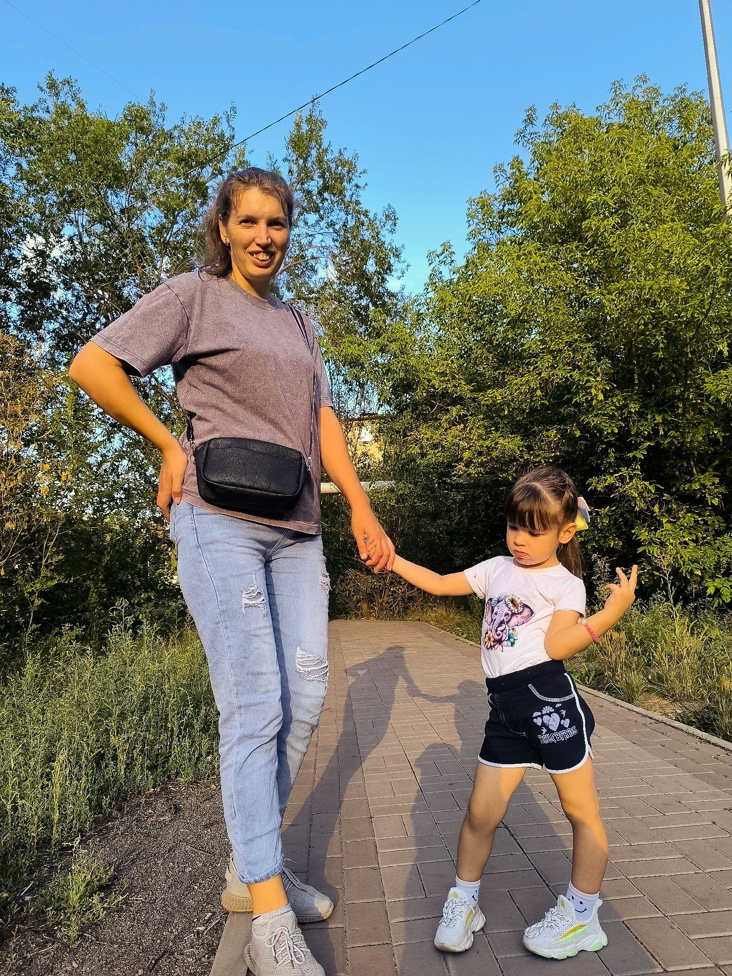 Smiling pair on a Karaganda pathway, catching a casual moment