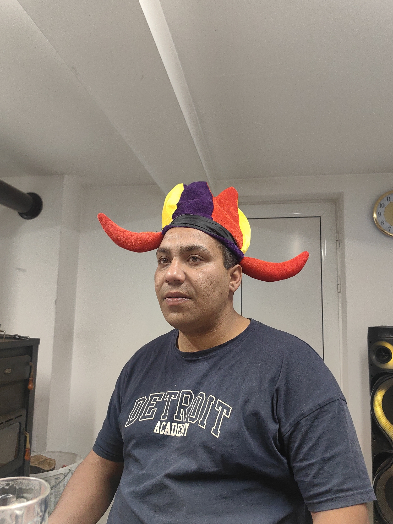 Man in jester hat dances in Bulgarian room