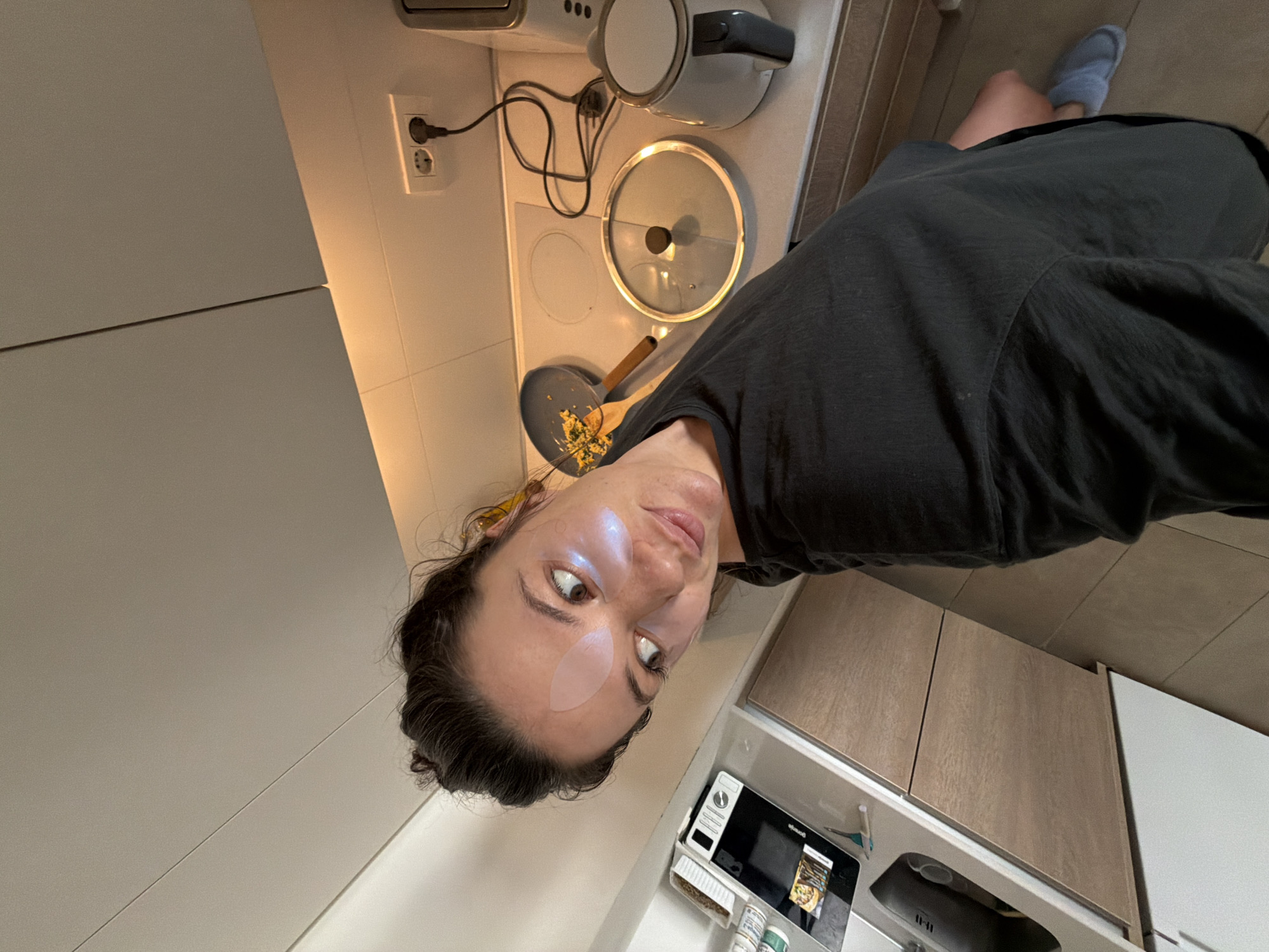 Woman multitasks cooking and selfie session in Belgrade kitchen