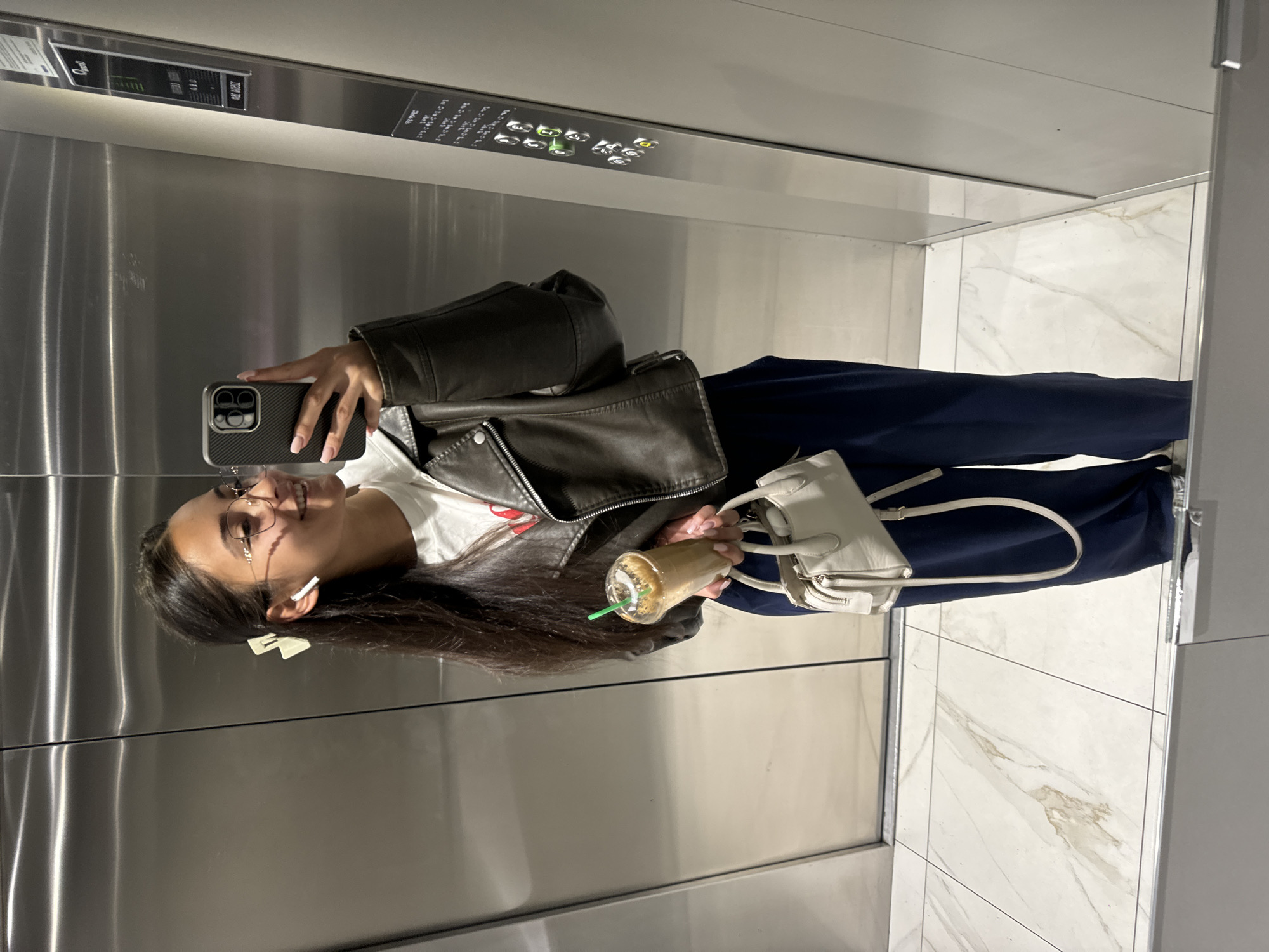 Woman takes selfie in marble-floored elevator in Sofia