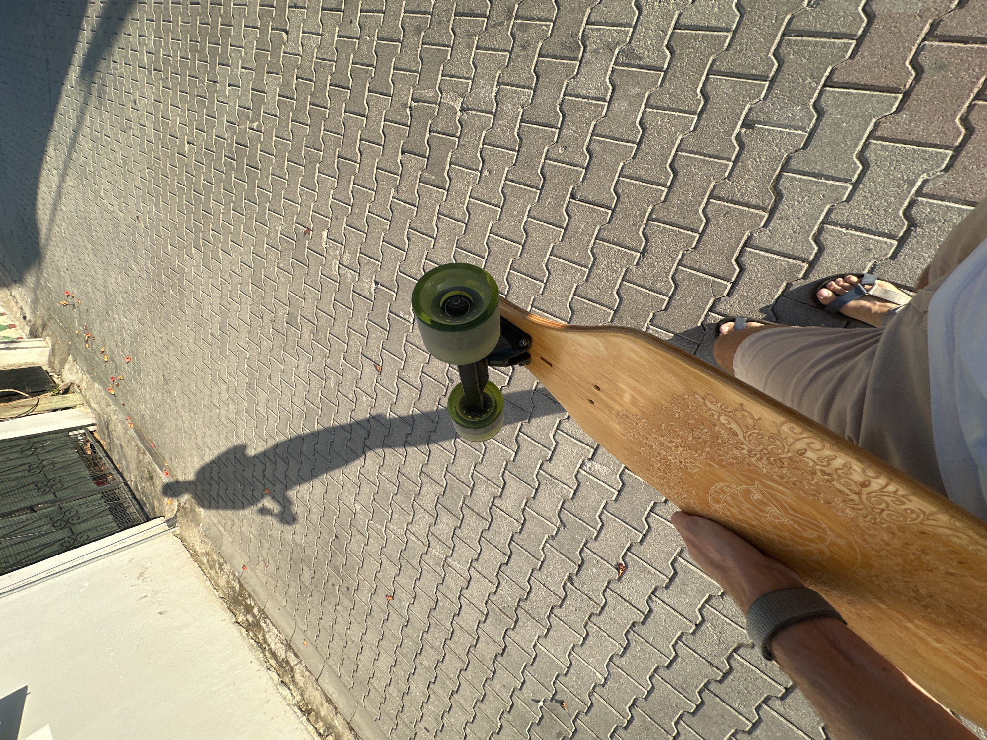Longboard and long shadows on a paved Fethiye walkway