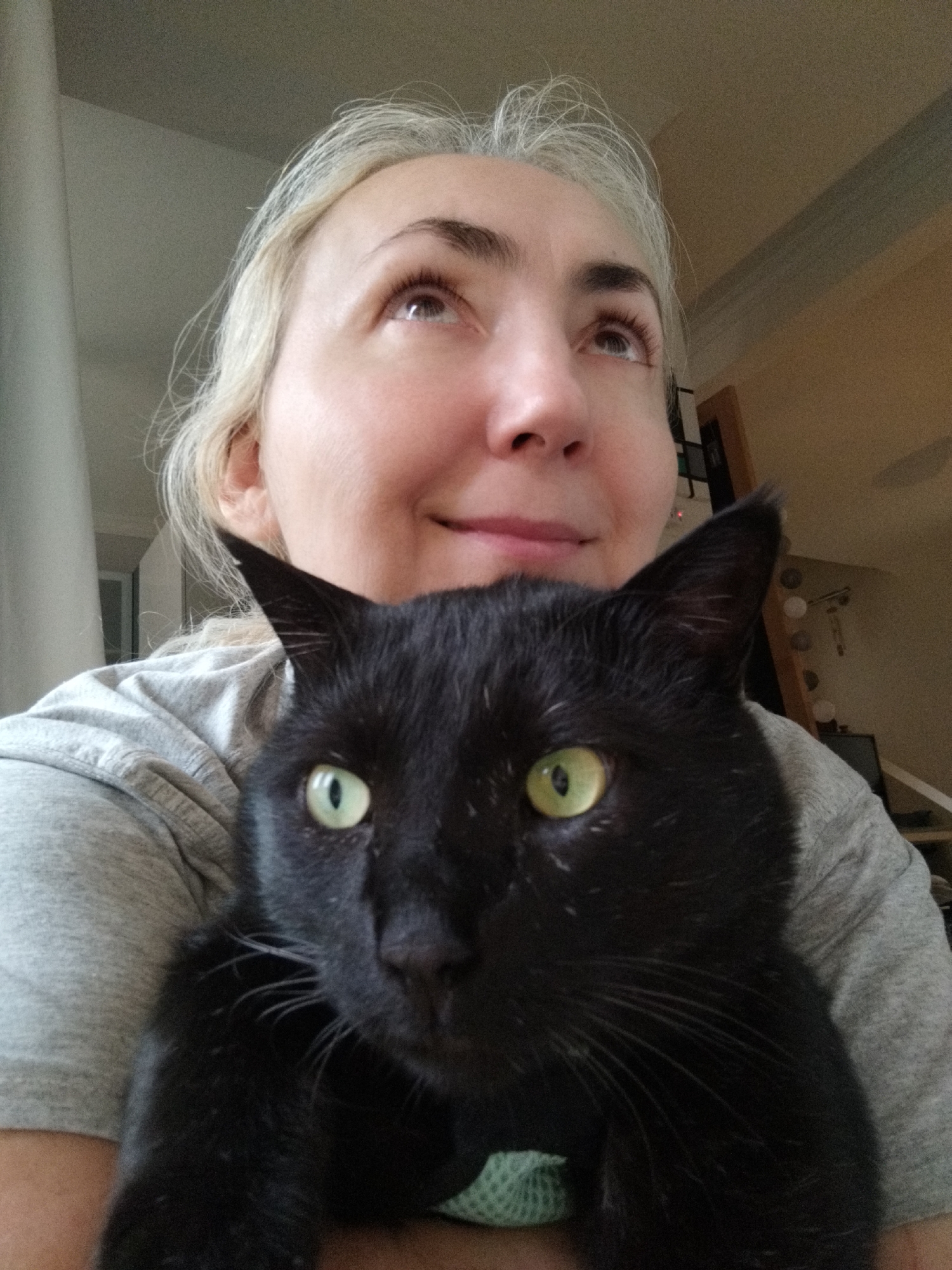 Woman holds black cat in casual portrait moment