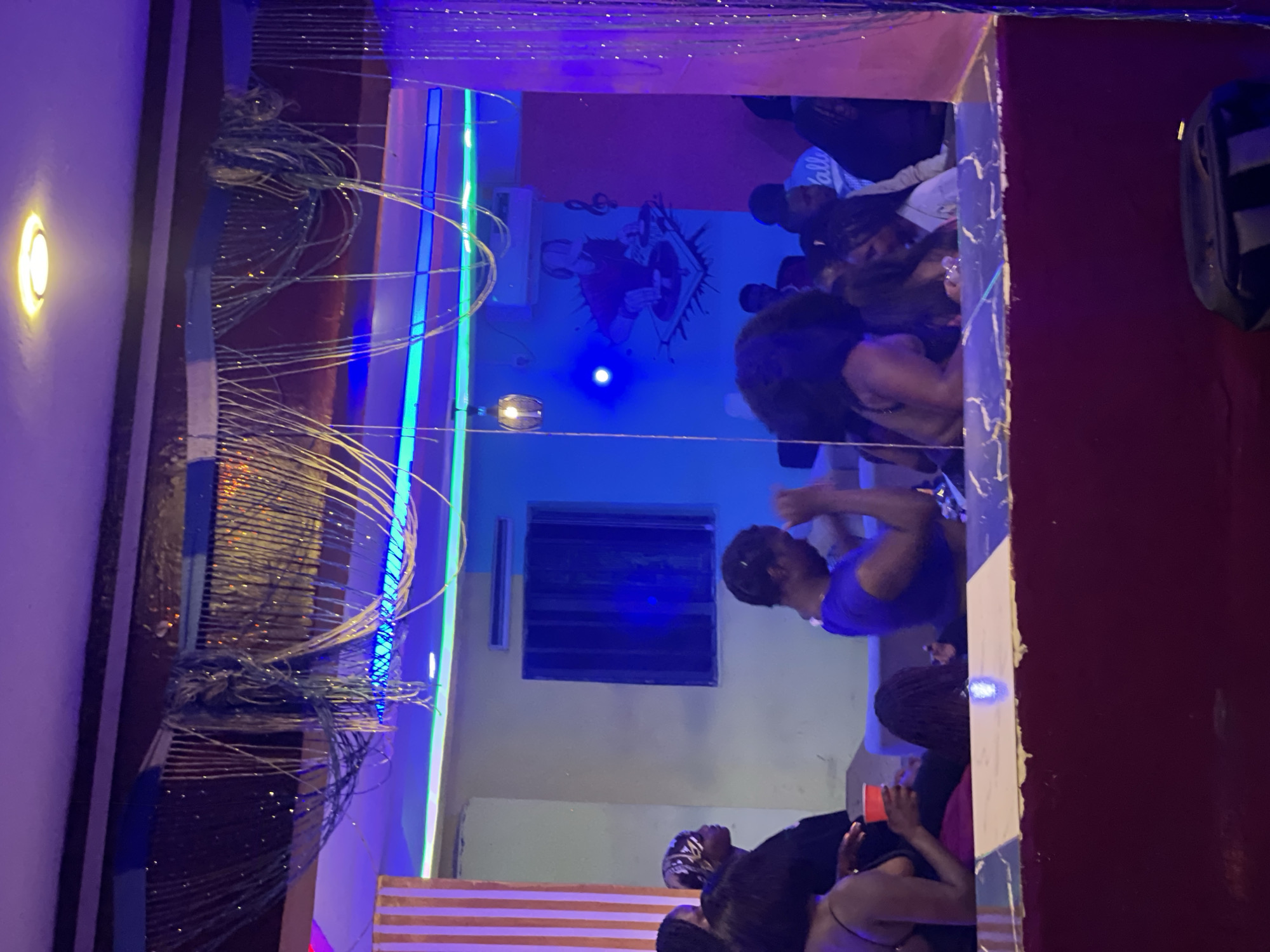 Late-night club scene at a neon-lit lounge in Durumi, Nigeria