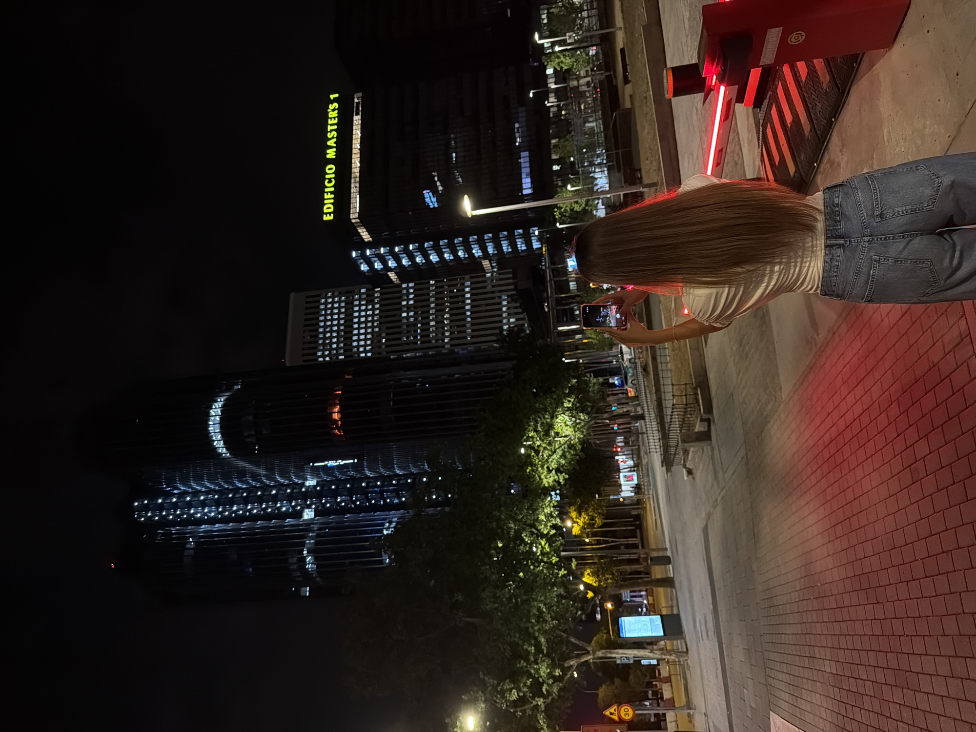 Nighttime shots around a lit modern tower in Madrid