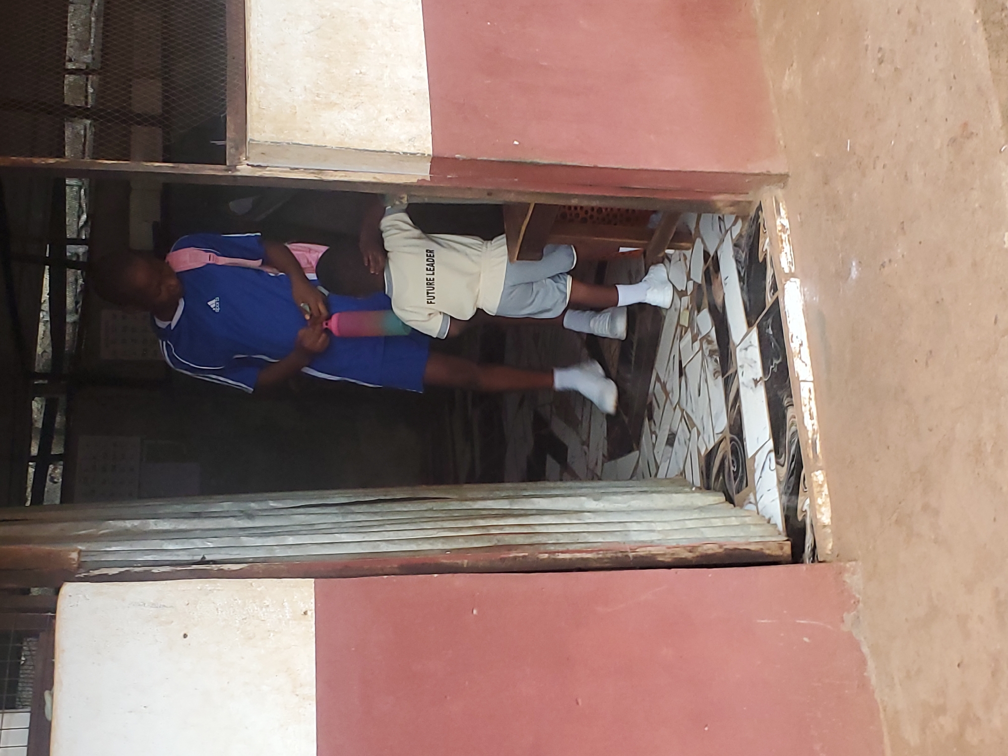 Children photographed in school uniforms around Ukwu-Abwa buildings