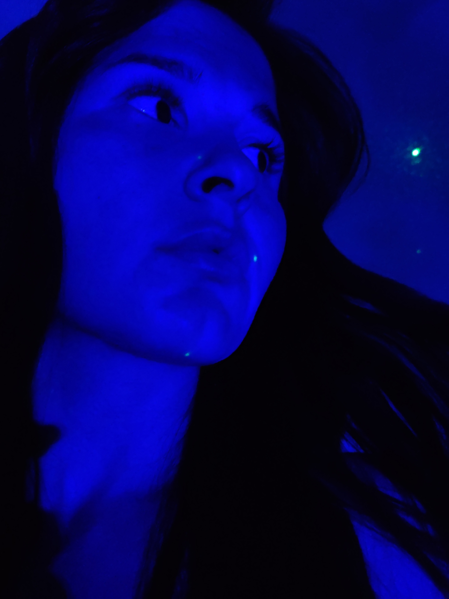 Person with playing cards observed under blue lighting in Foki