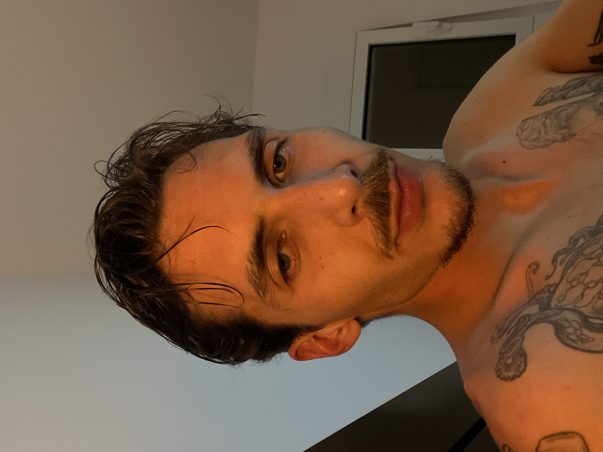 Man with wet hair and tattoos photographed in Rafailovići