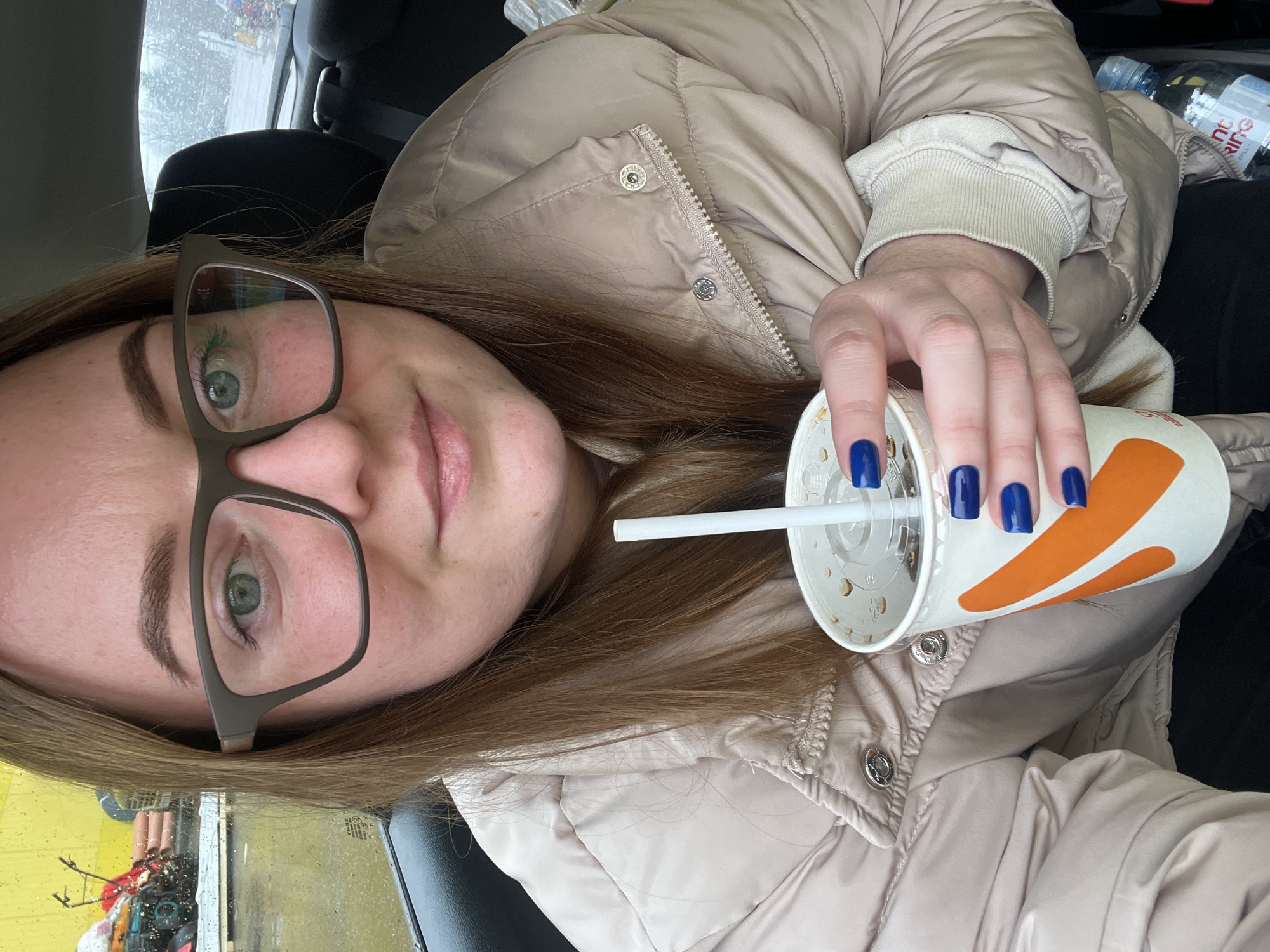 Woman takes selfies in car during rainy day