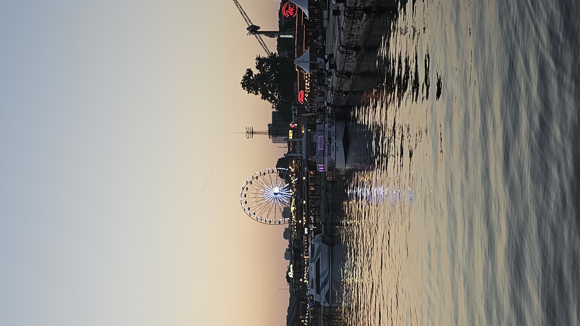 Varna harbor at dusk: Ferris wheel, sailboats, and a glowing sky