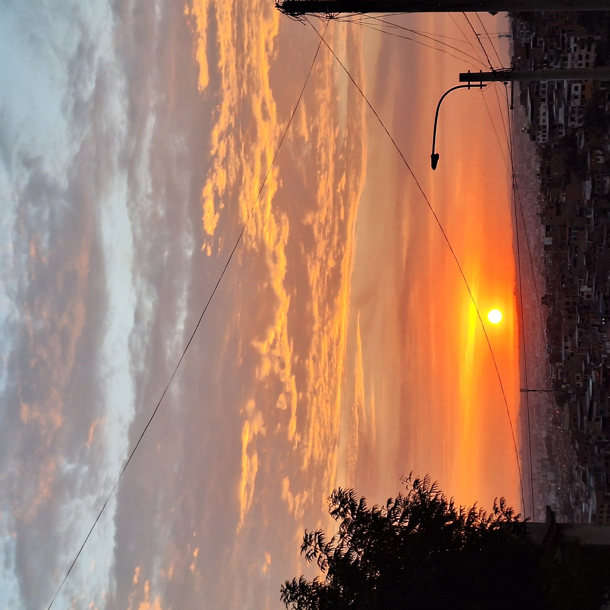 Fiery sunset illuminates dense housing in Mariano Melgar, Peru
