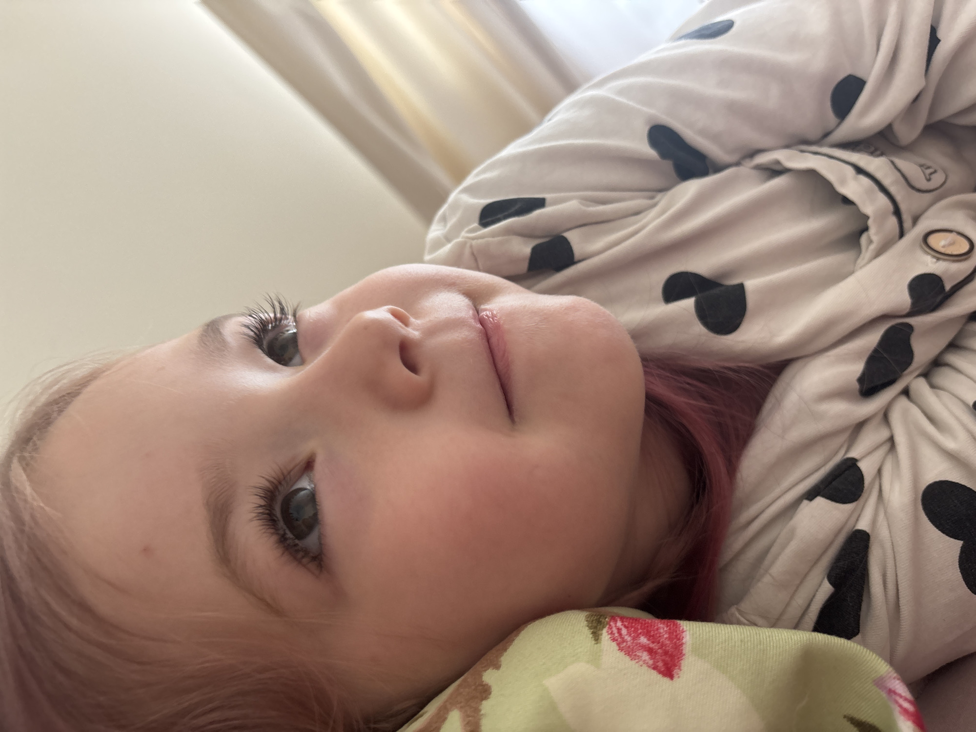 Quiet morning rest, heart-print pajamas and a strawberry pillow