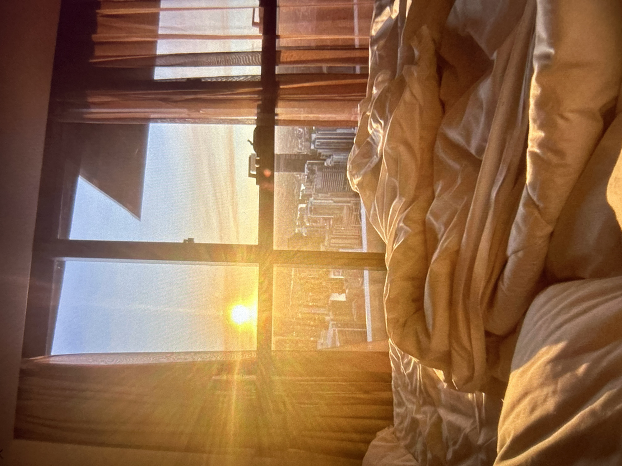 Sunrise spills through a bedroom window over a Bulgarian city