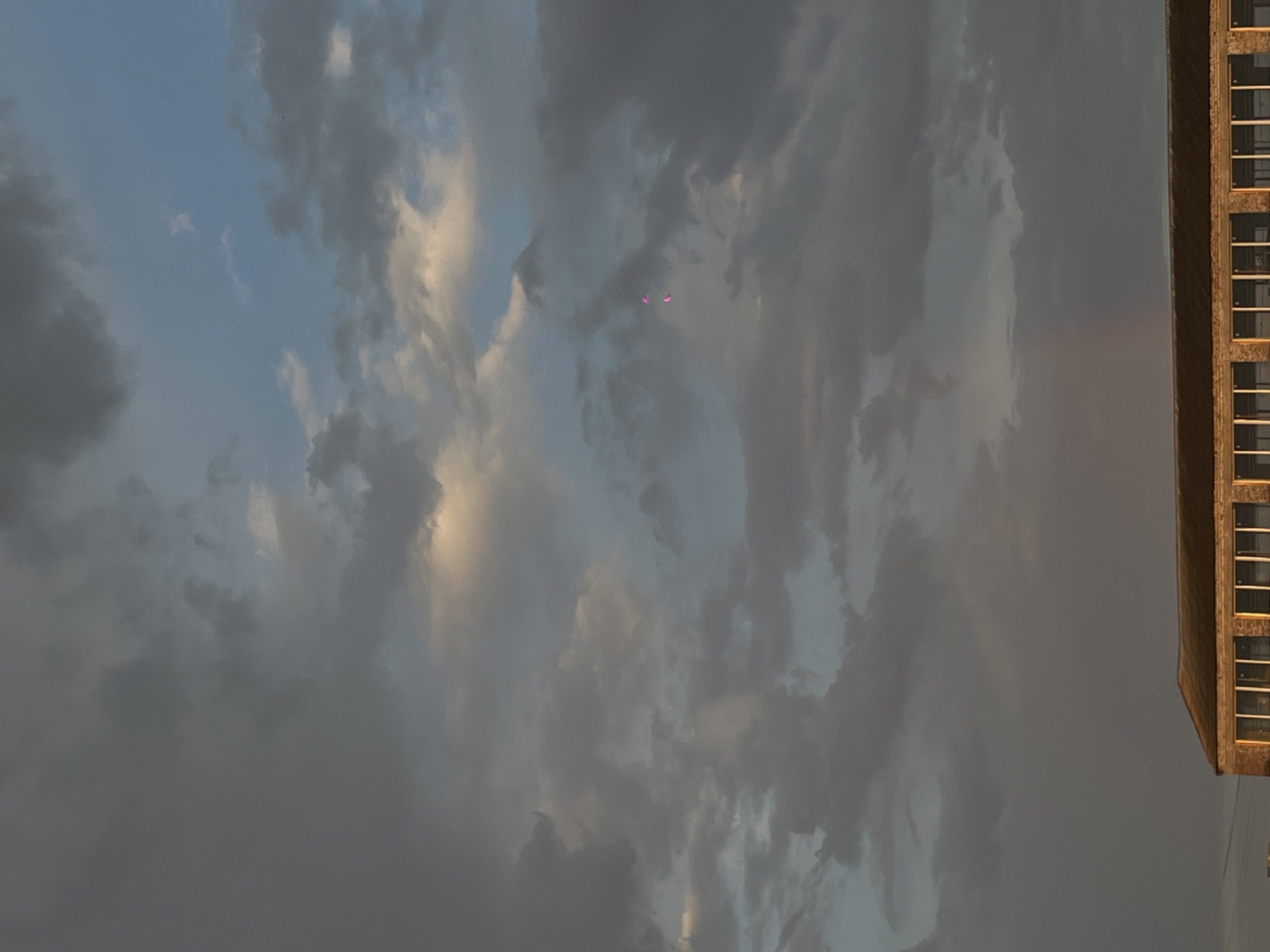 Cloudy afternoon sky photographed above building in Novopokrovskaya