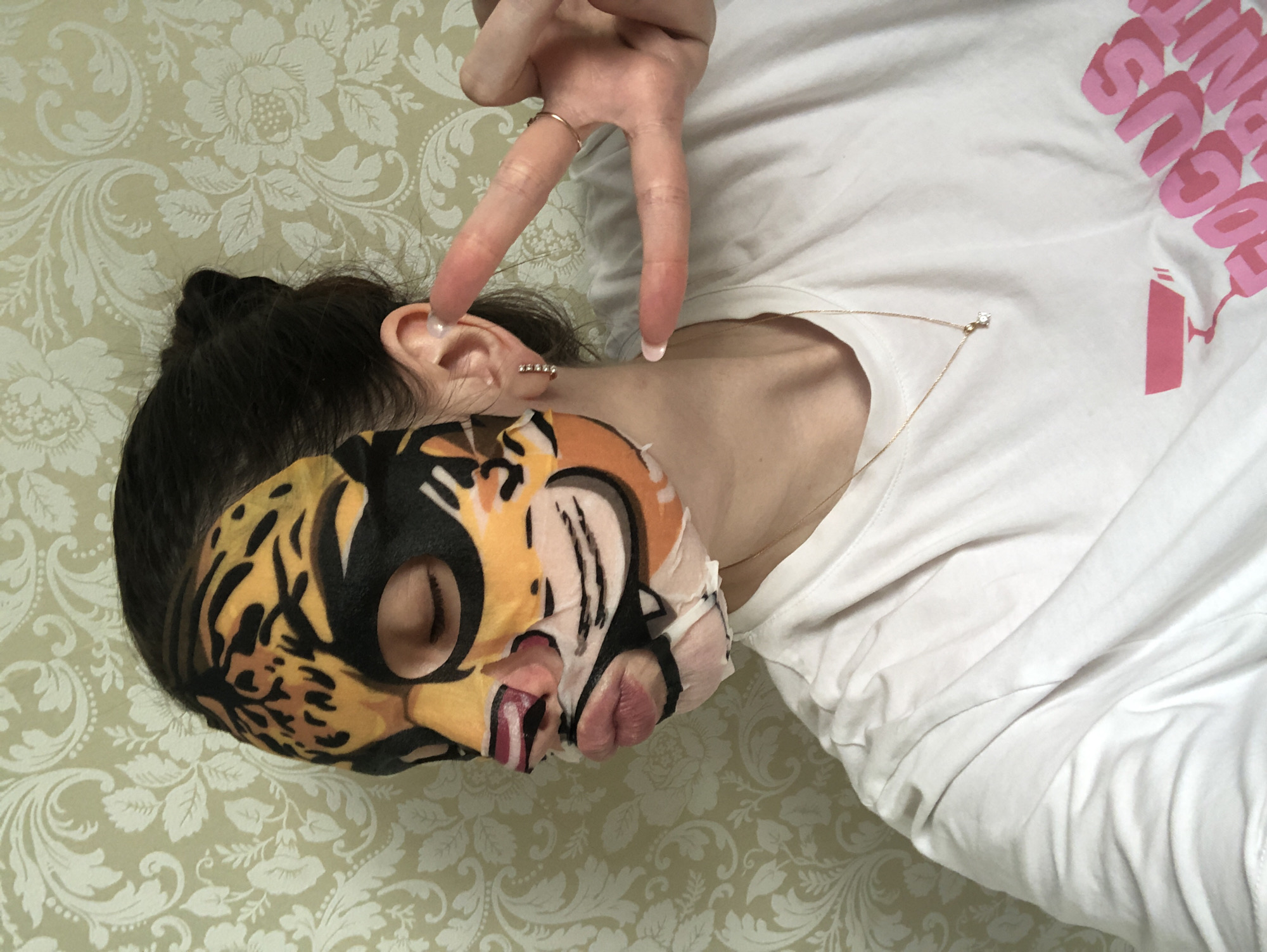 Person enjoys tiger-print face mask during skincare routine in Russia