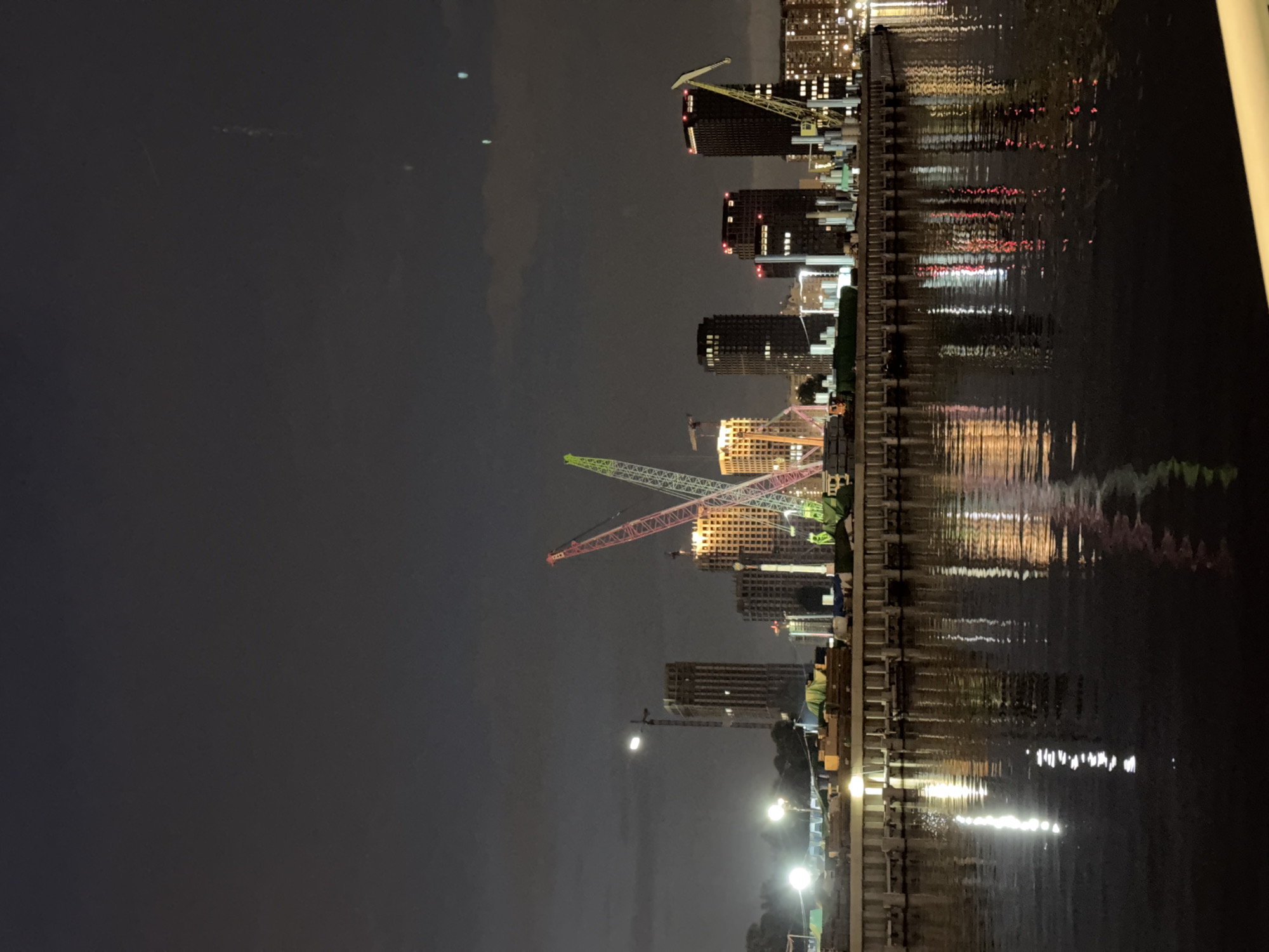 Moscow riverfront at night — cafés, cranes, and reflections