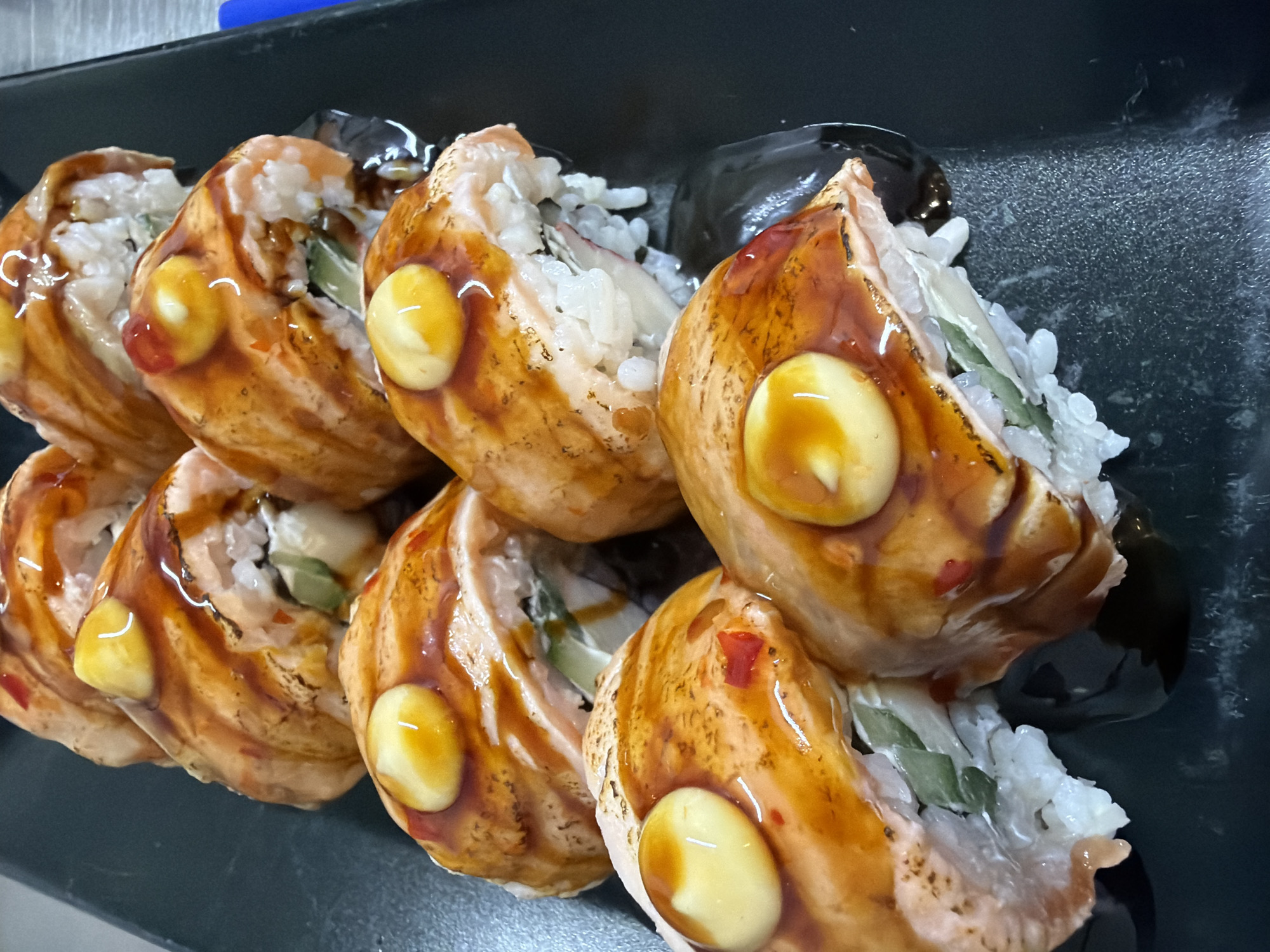 Salmon sushi photographed on black plate in Pleven, Bulgaria