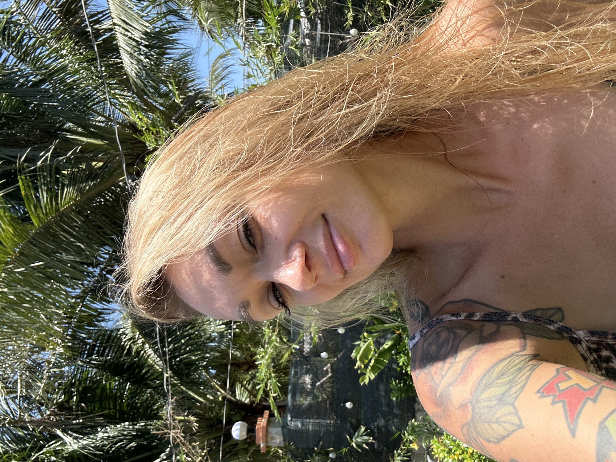 Blonde woman photographs selfies in tropical Mũi Né, Vietnam