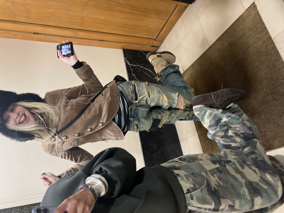 Two people take mirror selfies in Paris hallway