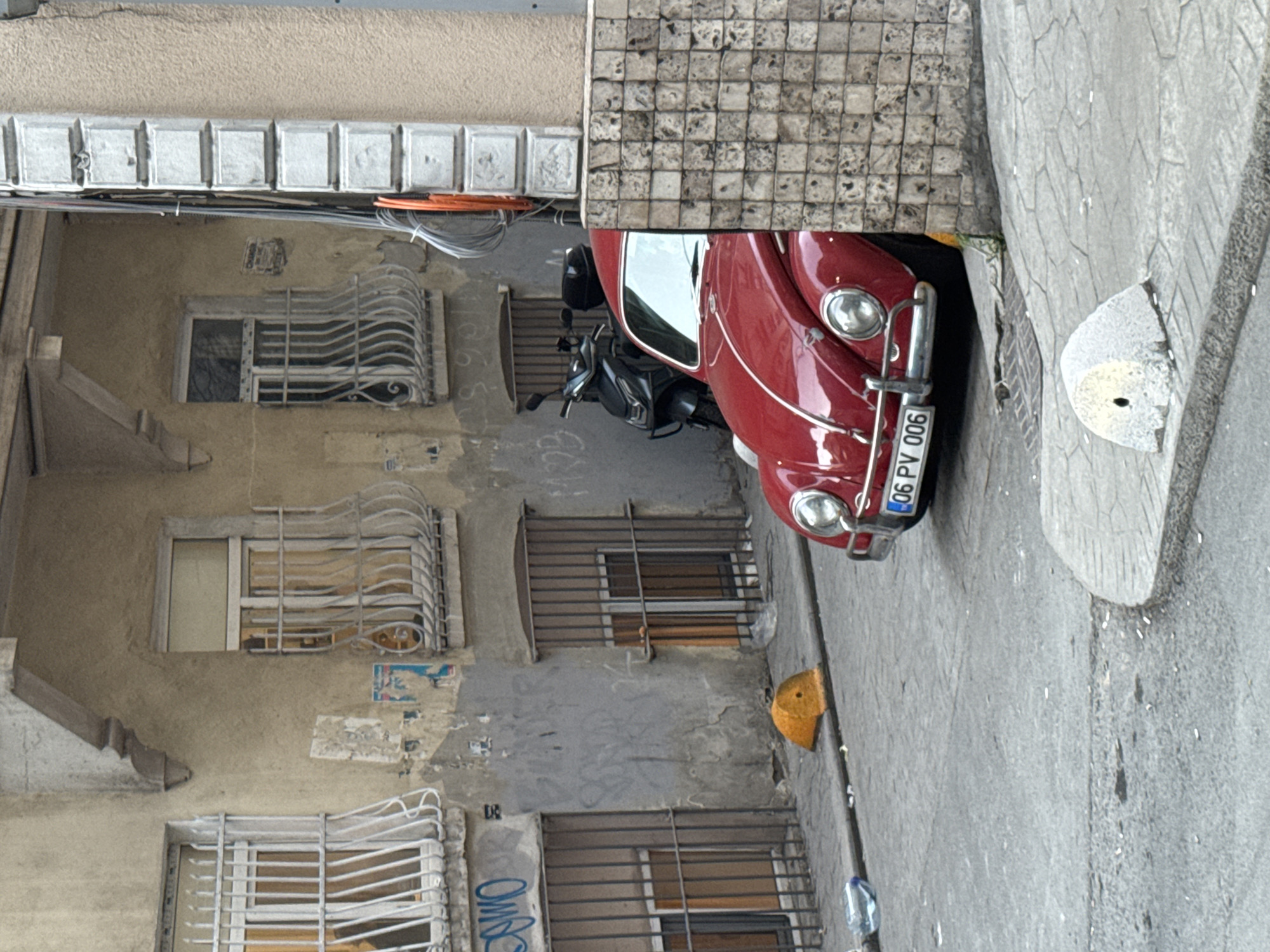 Classic red Volkswagen Beetle spotted on narrow Beyoğlu street