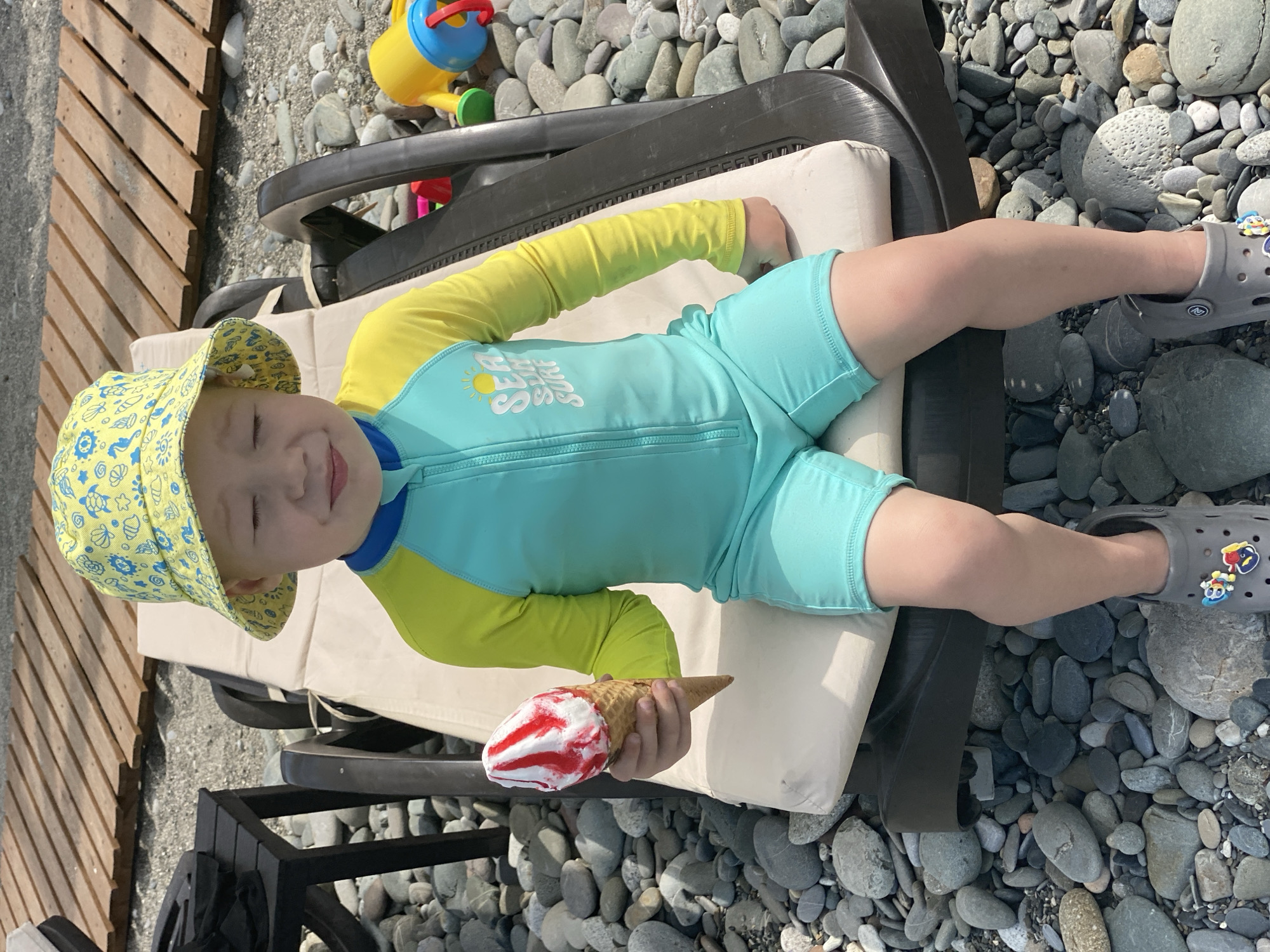 Child enjoys ice cream at Sochi beach morning