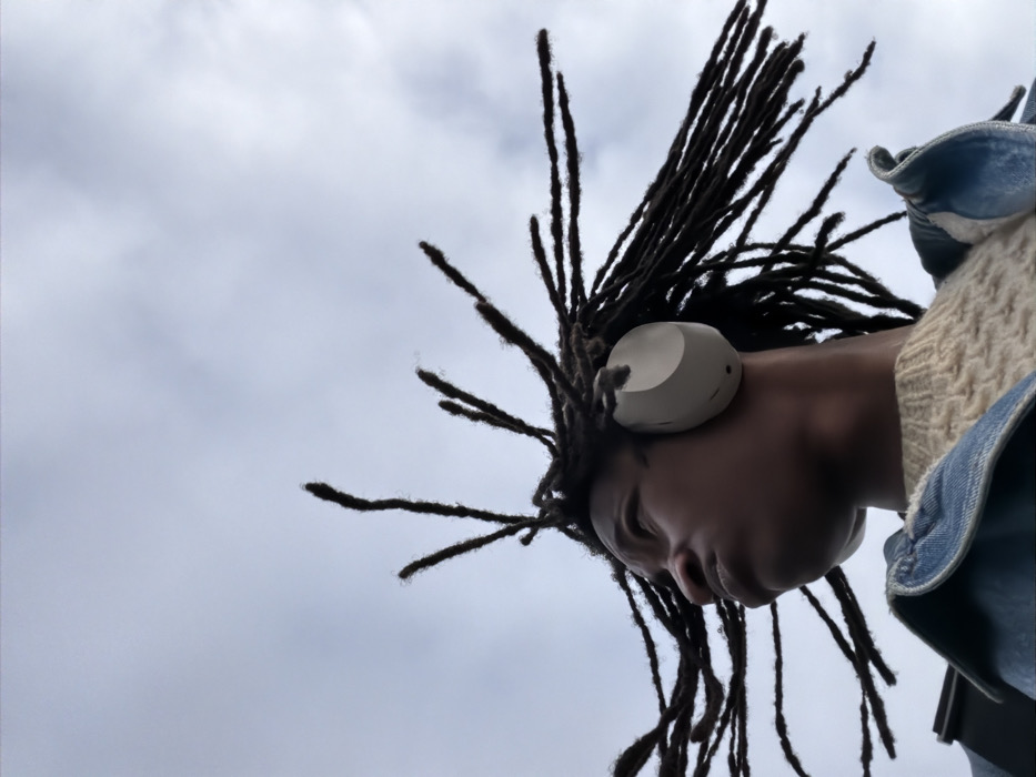 Person with dreadlocks gazes skyward in Rosny-sous-Bois
