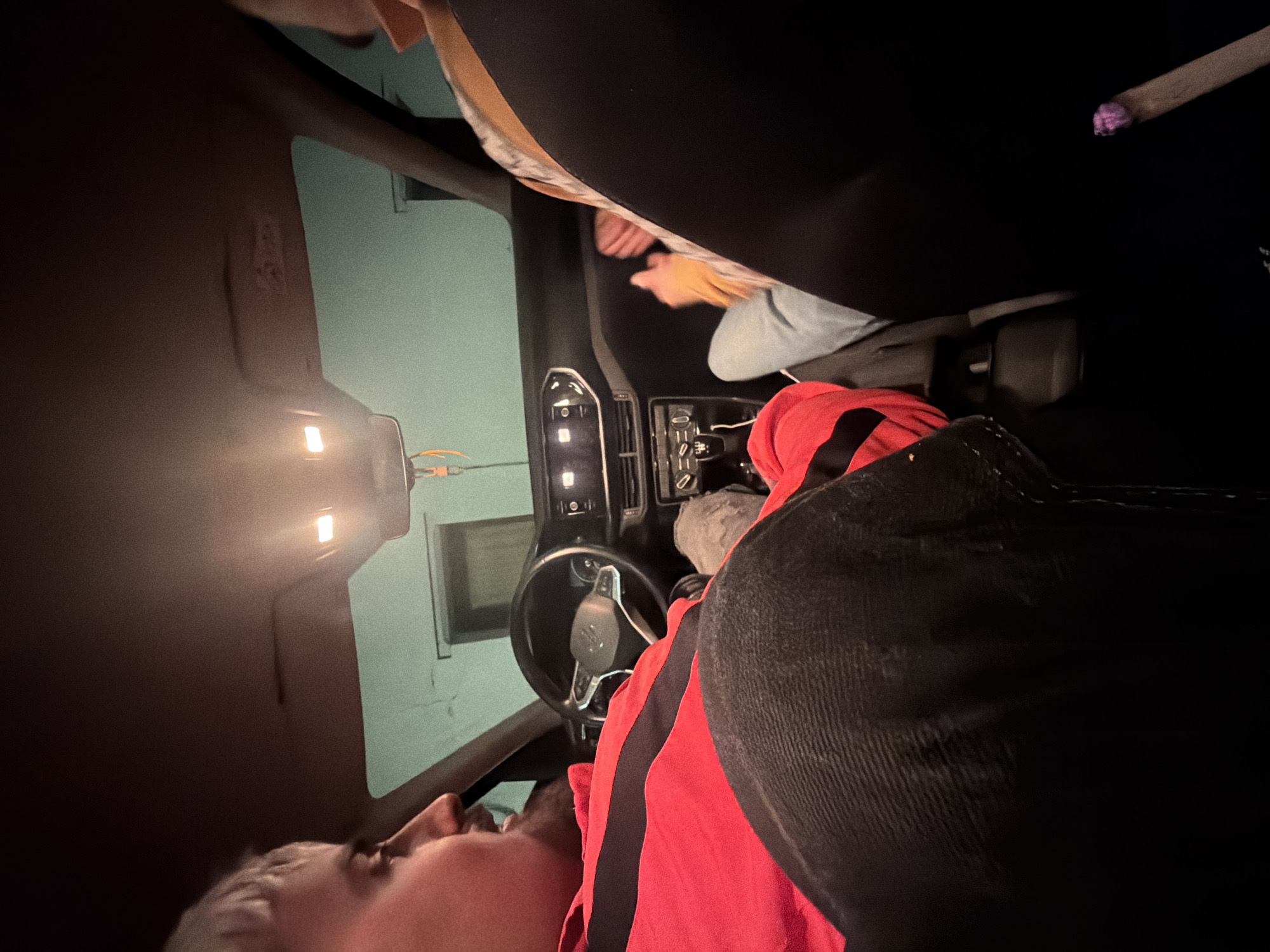 Person lying in driver's seat of car in Vila Real