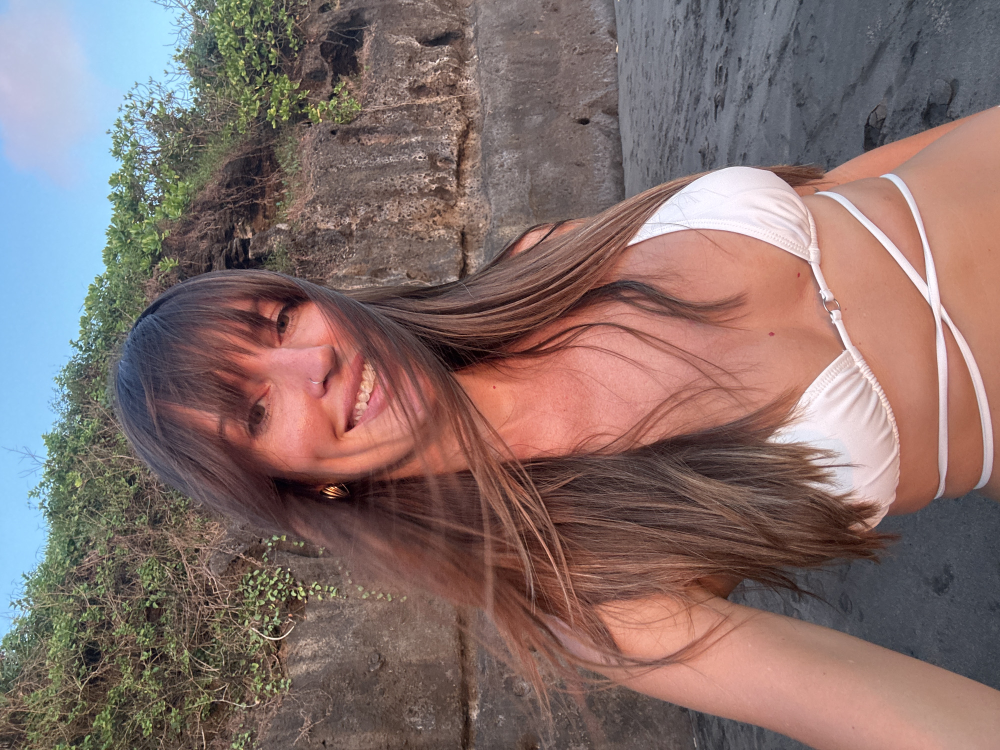 Woman photographed smiling at cliffside location in Tabanan, Indonesia