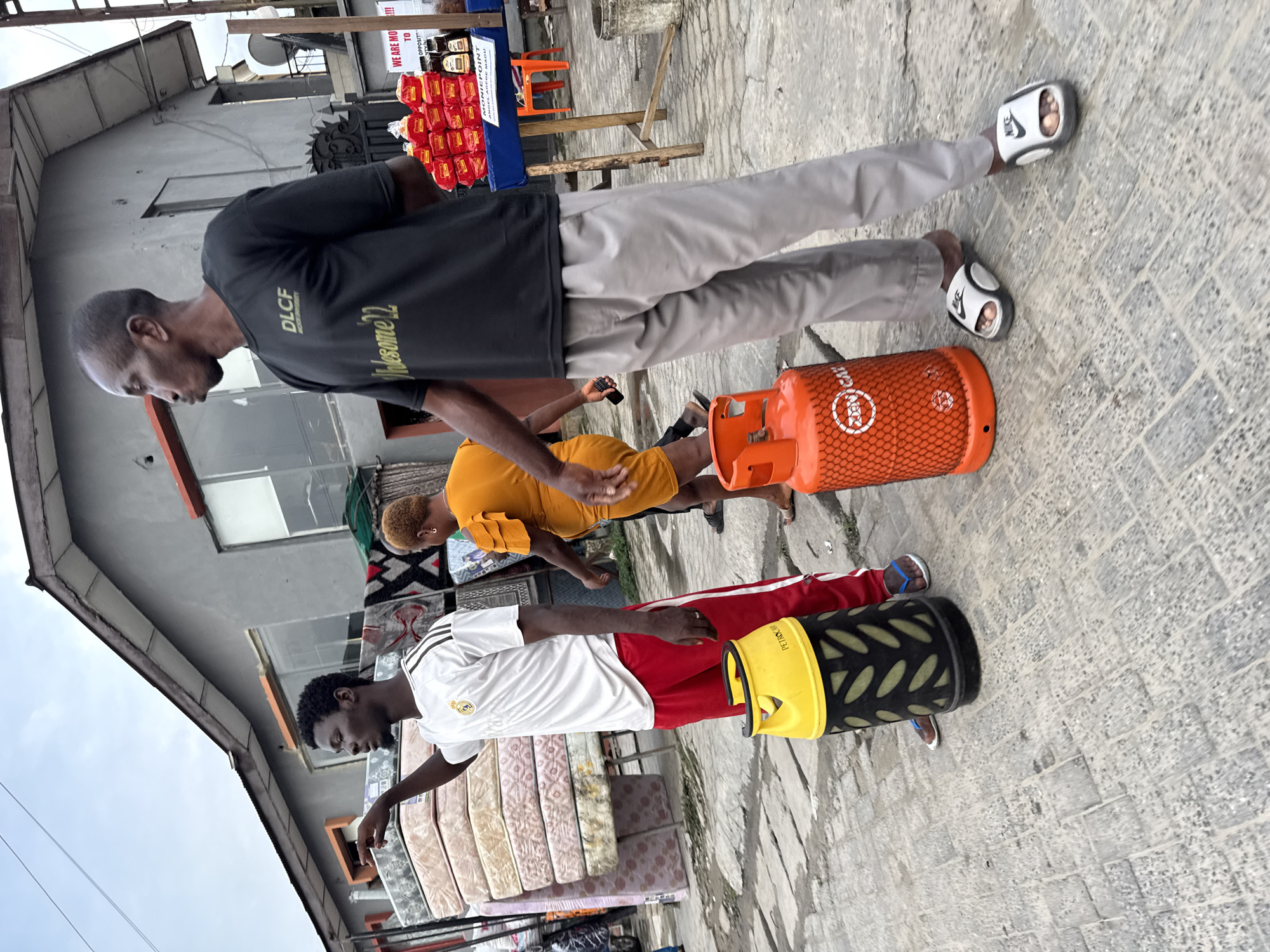 Everyday street activity outside shops in Ado, Nigeria