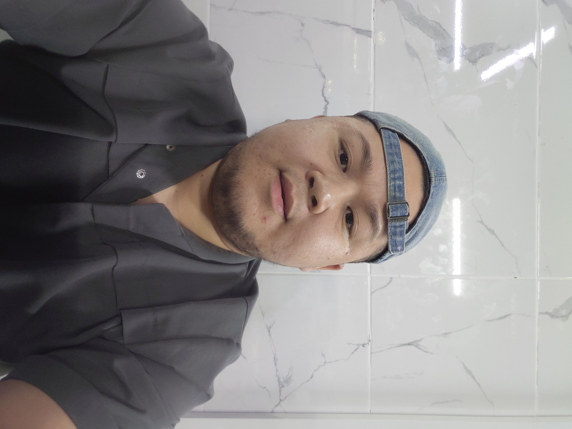 Selfie session in an Aktau restroom, same shirt, multiple moods