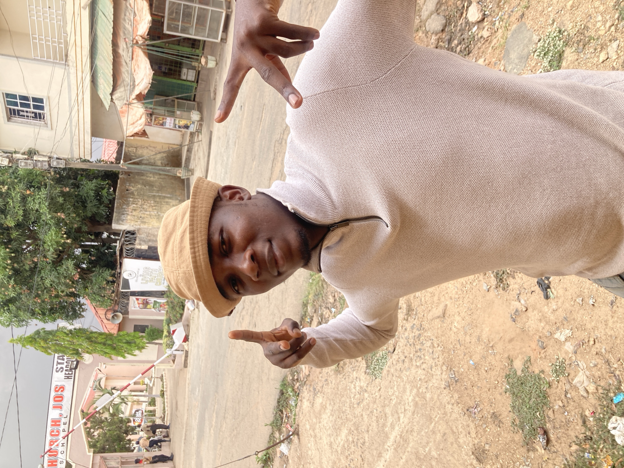 Young man poses, dances on Jos street in playful photo session