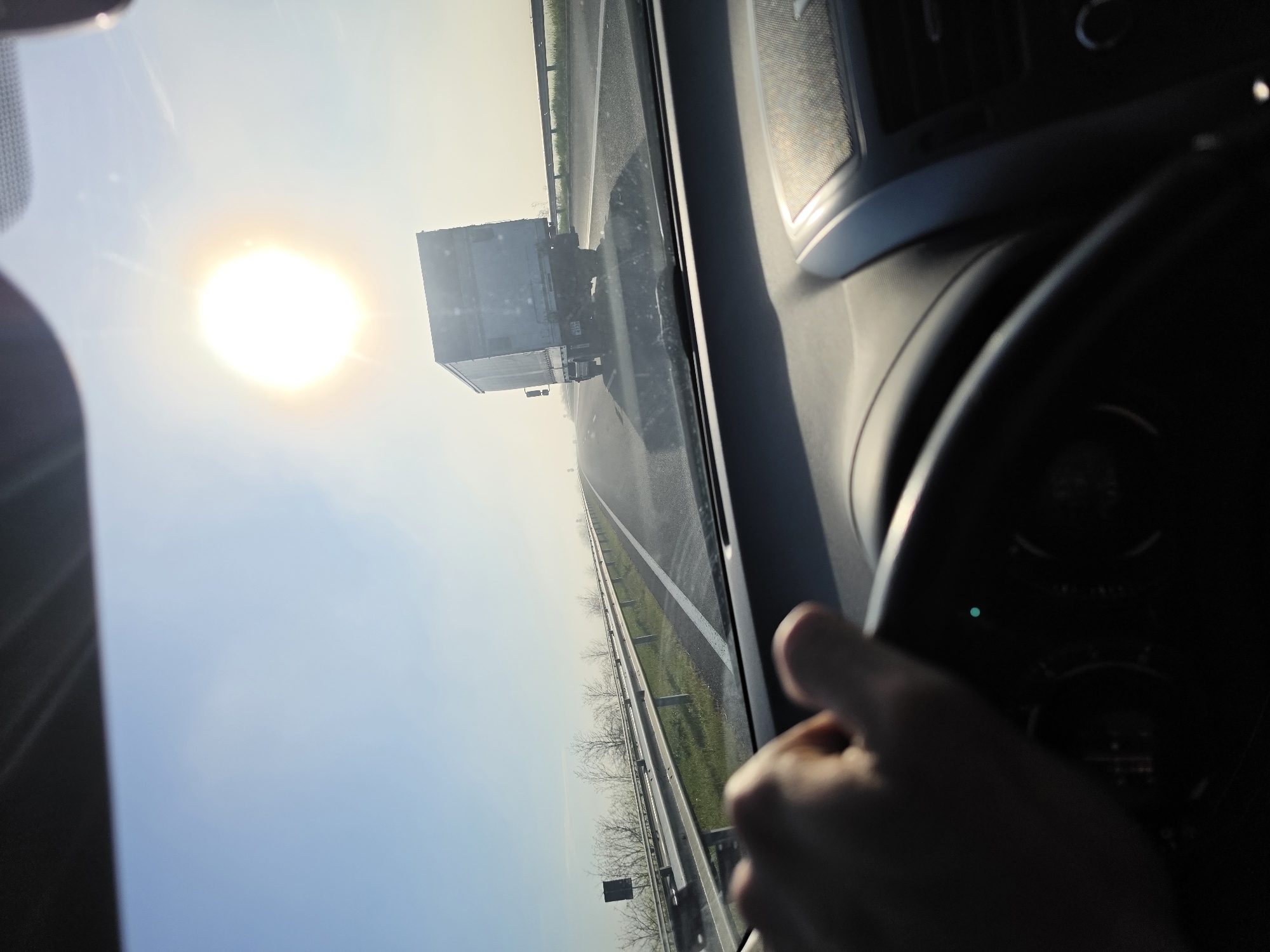 Morning highway drive captured with truck ahead, sunny skies