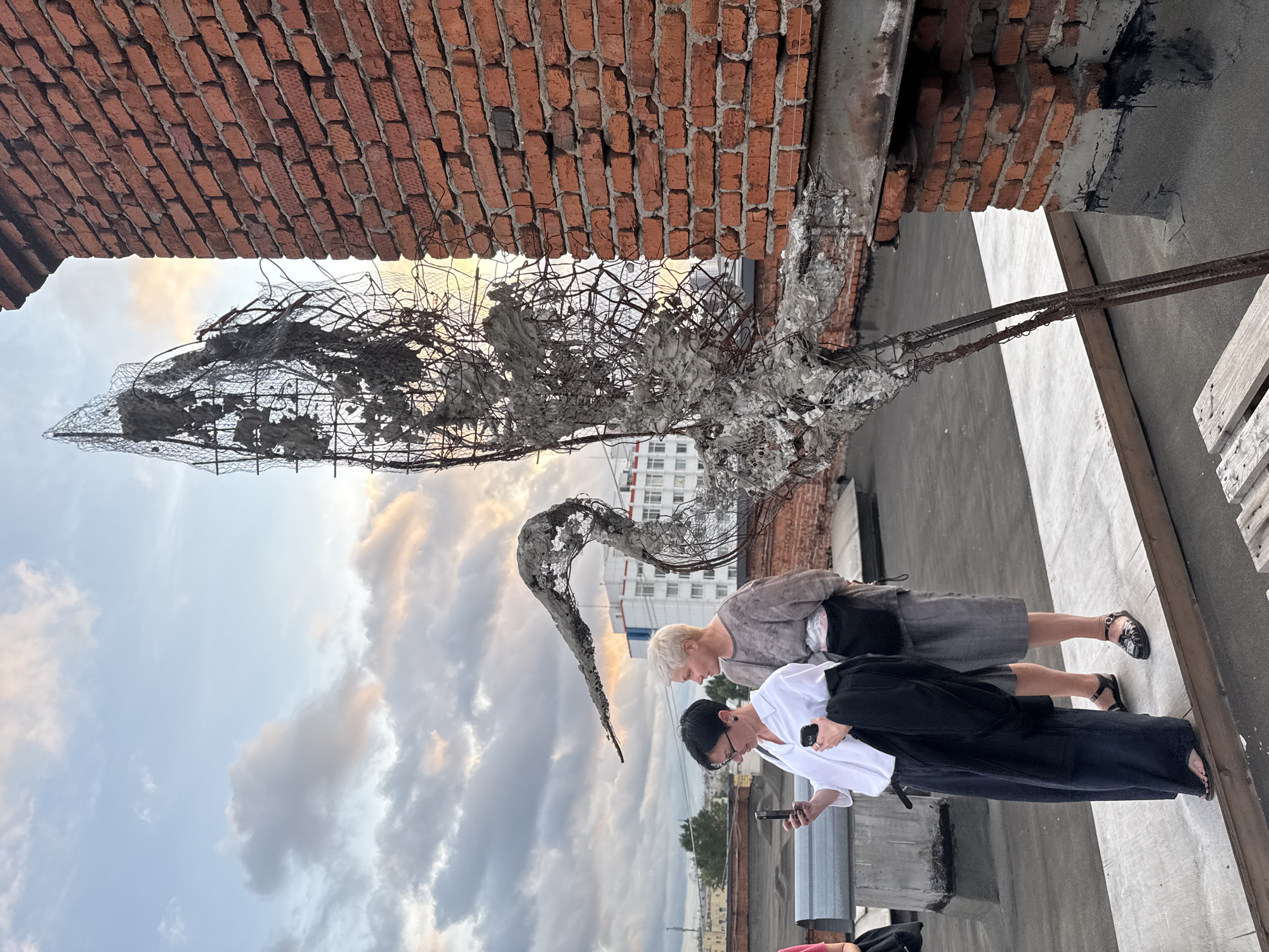 Rooftop art event at a Moscow industrial venue, stormy sunset
