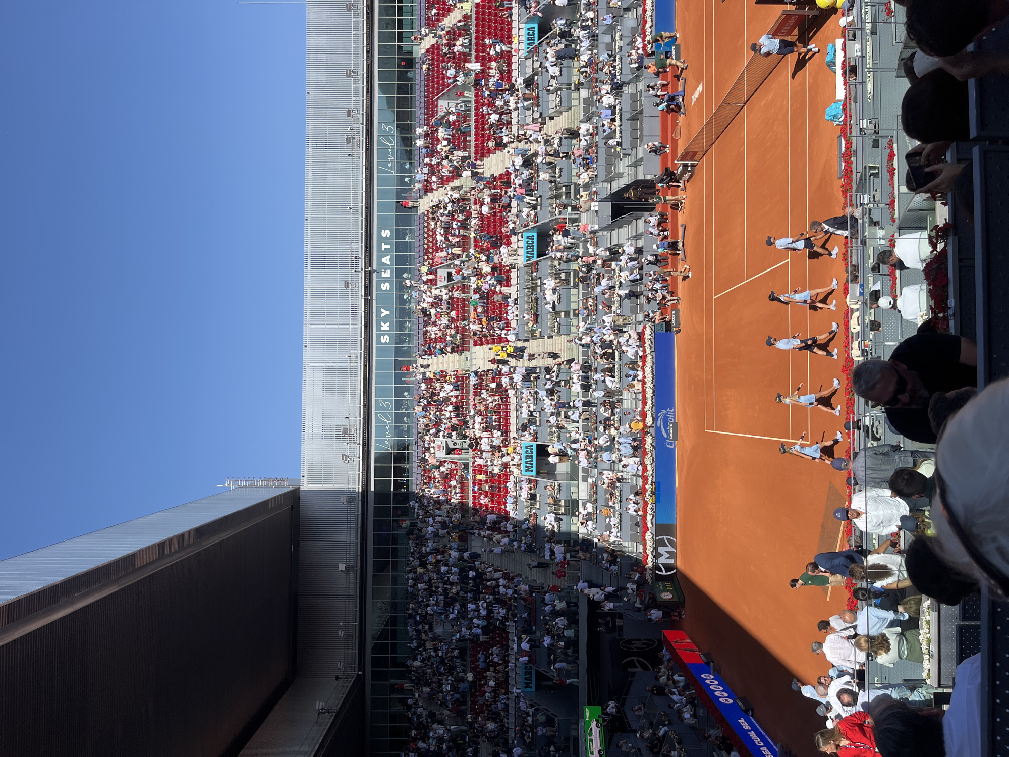 Professional tennis match underway on clay court in Madrid