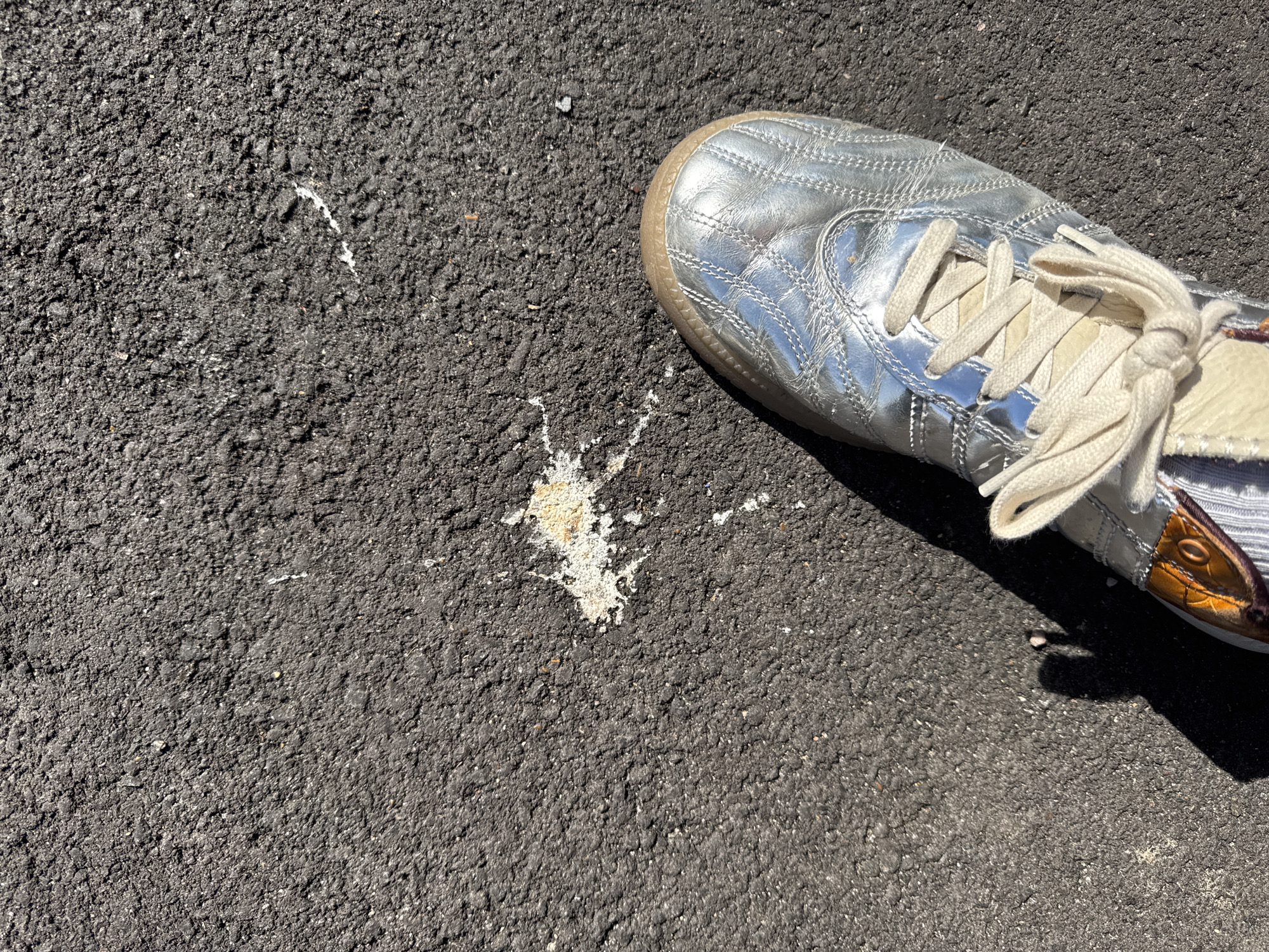 Person rests on pavement in distinctive footwear, Folkestone district