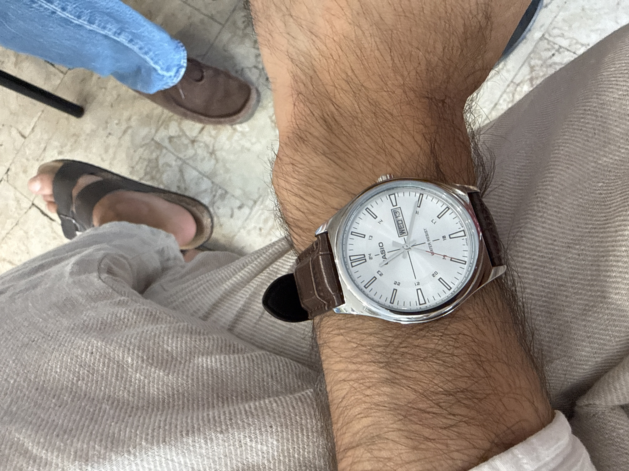 Milan office wrist check: silver watch, leather strap, hourglass desk