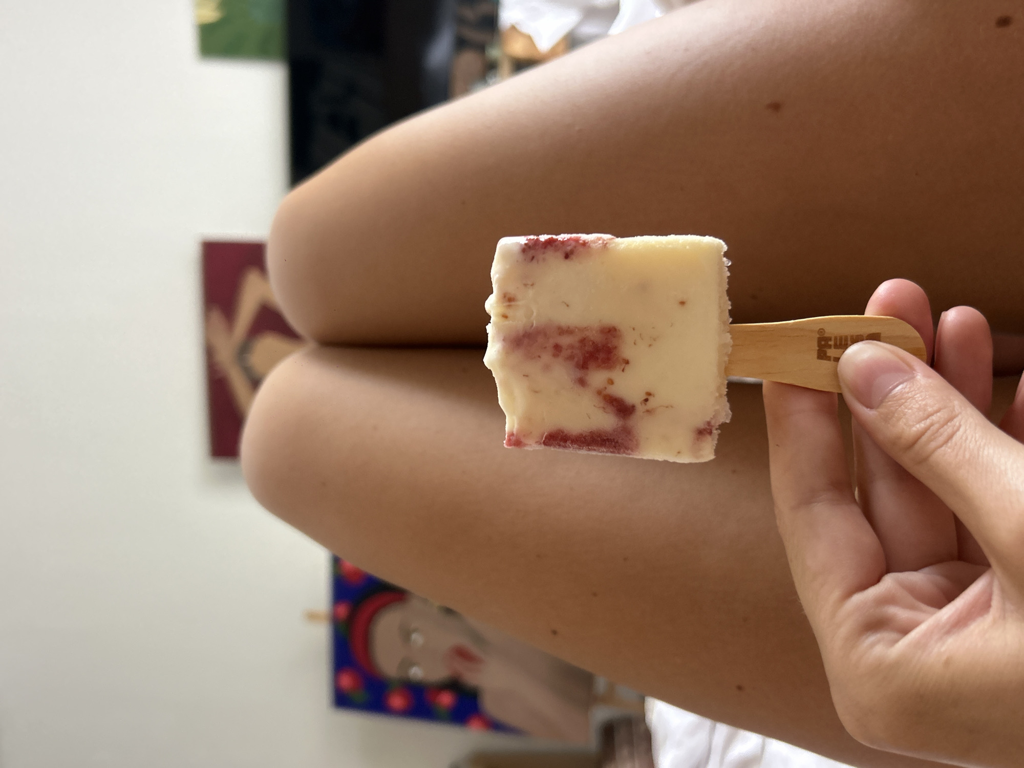 Person enjoys red-swirled popsicle in North Kuta residence