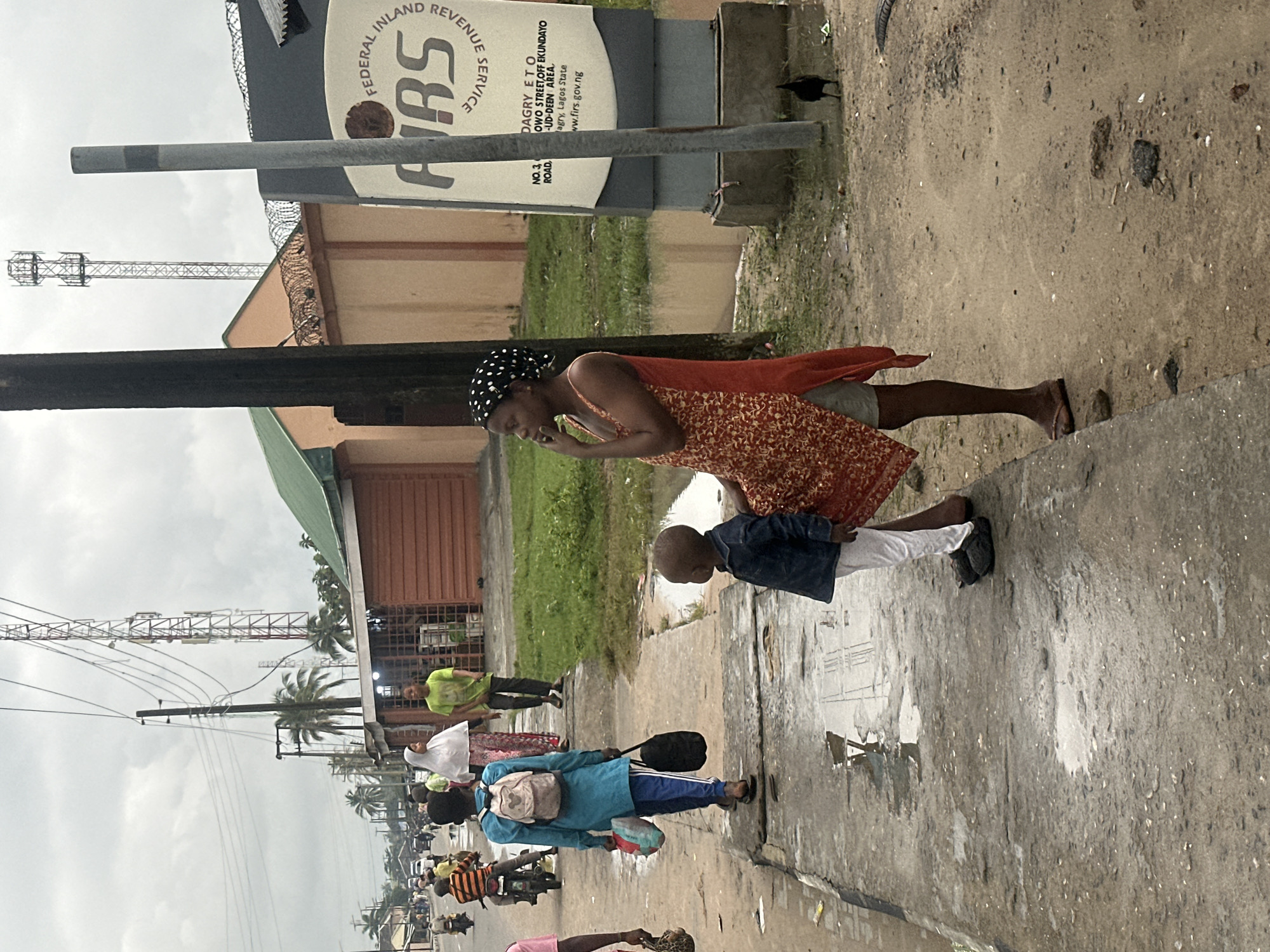 Morning foot traffic through Badagry streets under heavy cloud cover