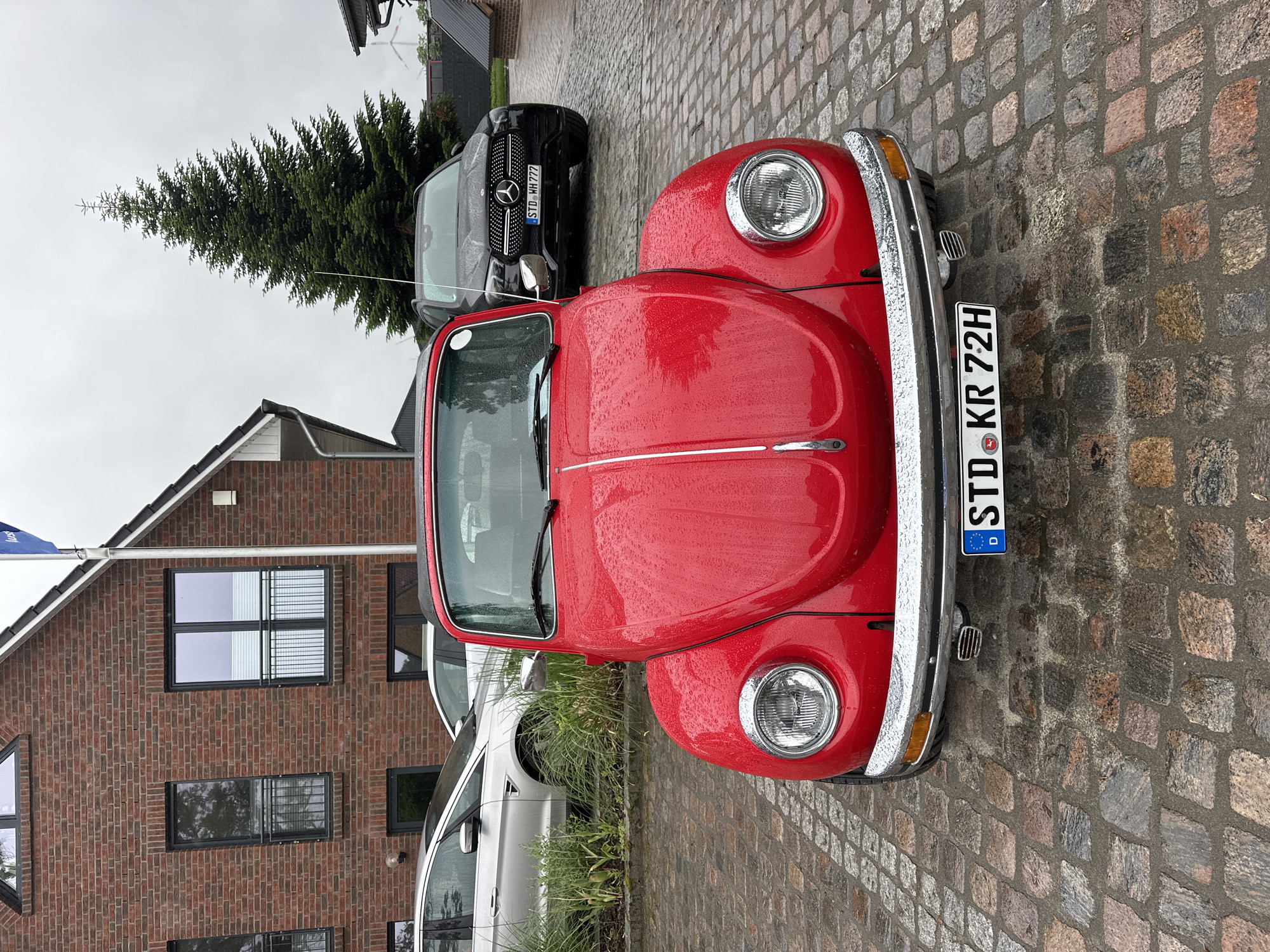 Rainy morning gathering documented in Deinste, Germany features classic cars