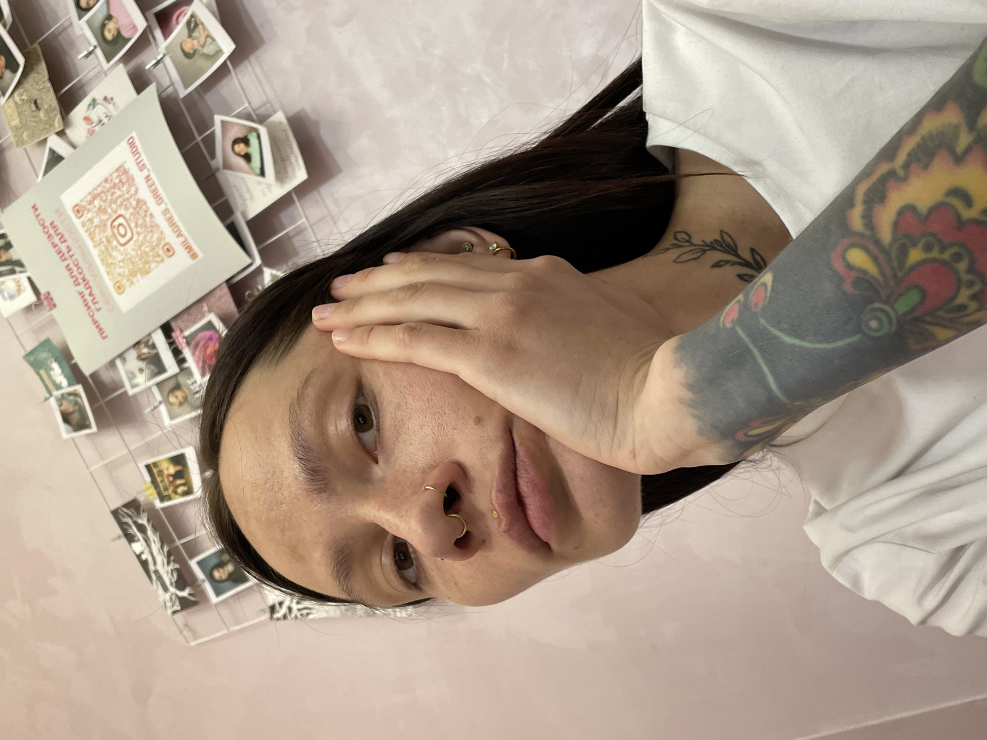 Tattooed person photographed against pink wall in Izhevsk