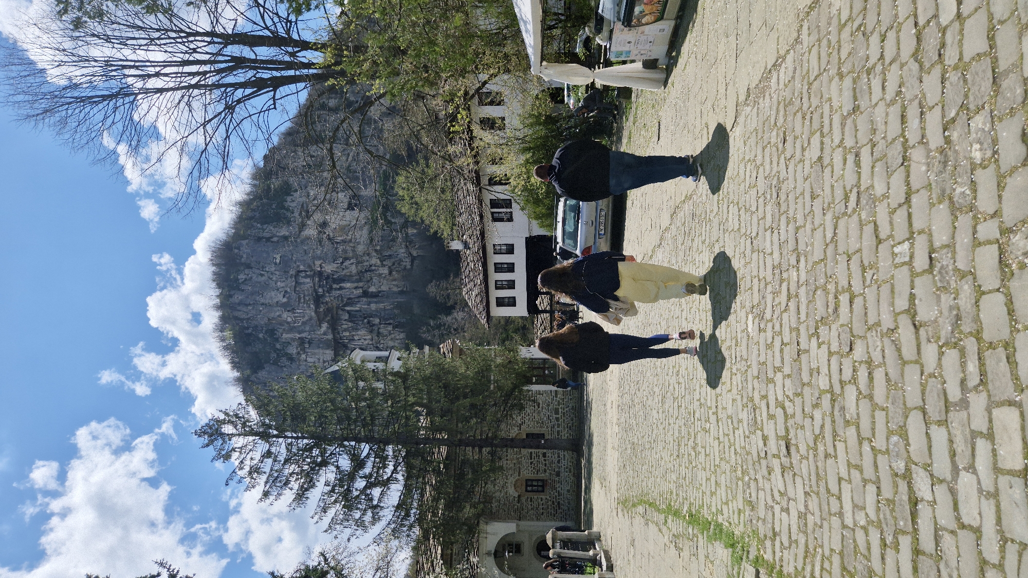 Pedestrians observed near traditional buildings in Bulgarian mountain region